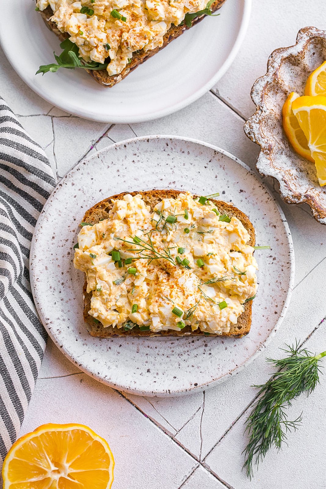 Sliced bread with egg salad on a plate.