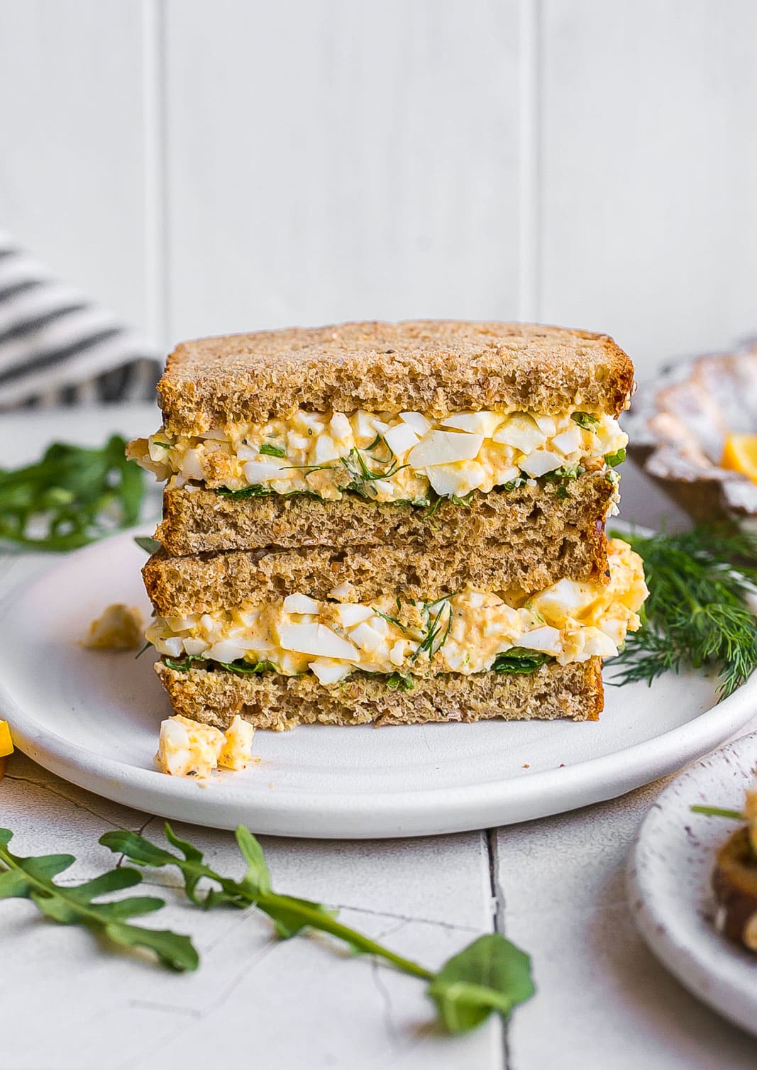 Egg Salad sandwiches stacked on a plate.