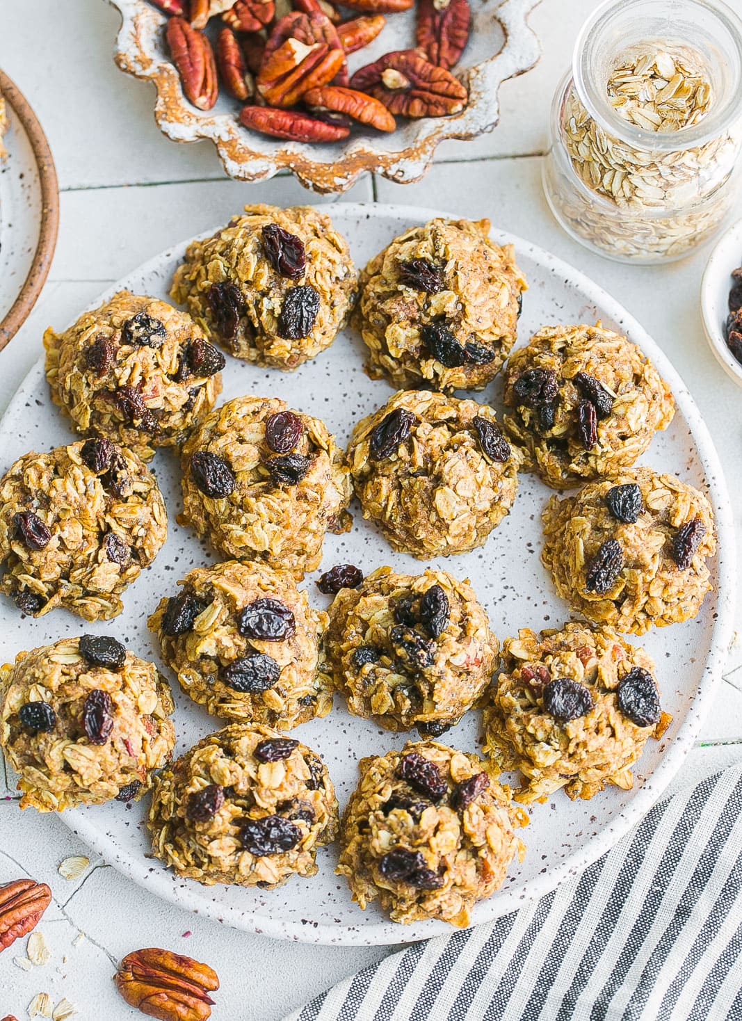 Oatmeal cookies on a plate with pecans and raisins.