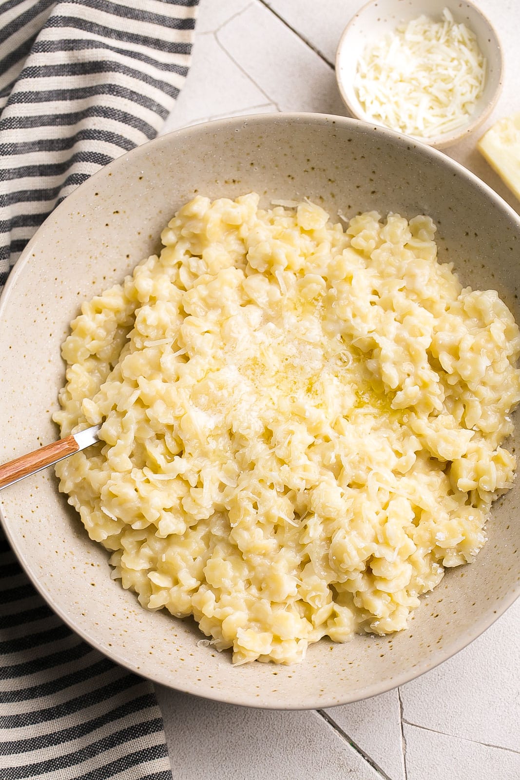 The best pastina recipe in a bowl with melted butter and parmesan cheese.