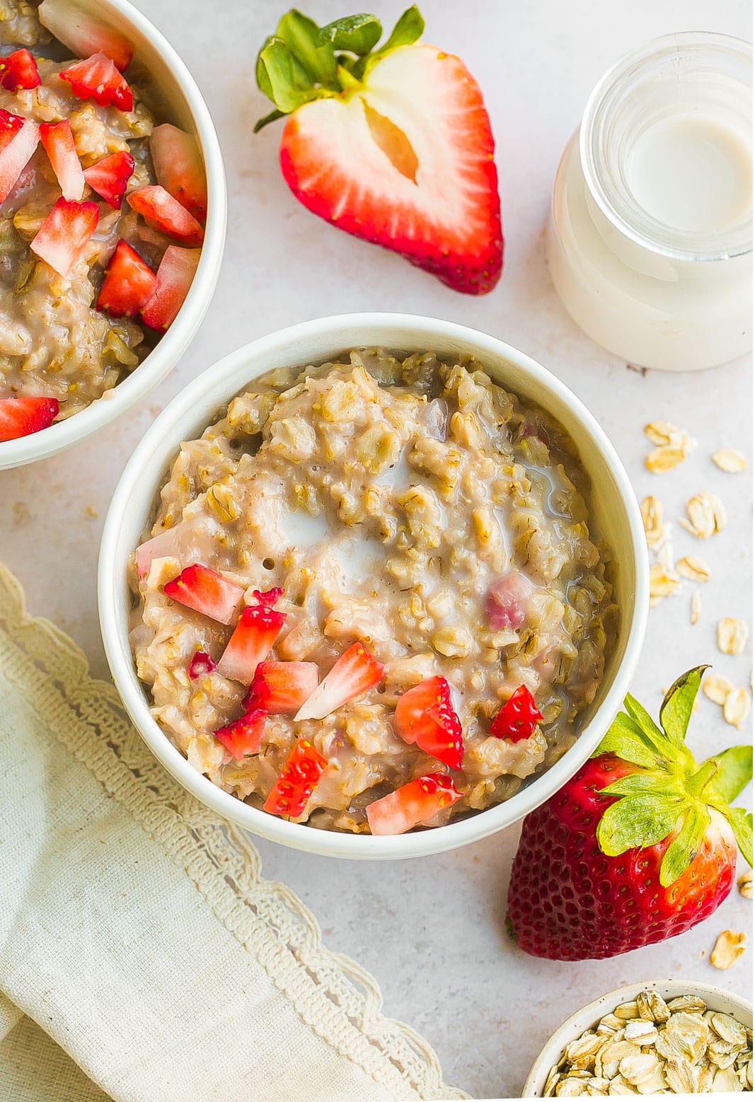 Bowl oatmeal with chopped strawberries and oats. 