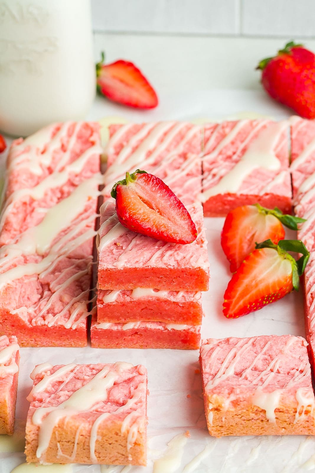 Side angle view of strawberry brownies with icing.