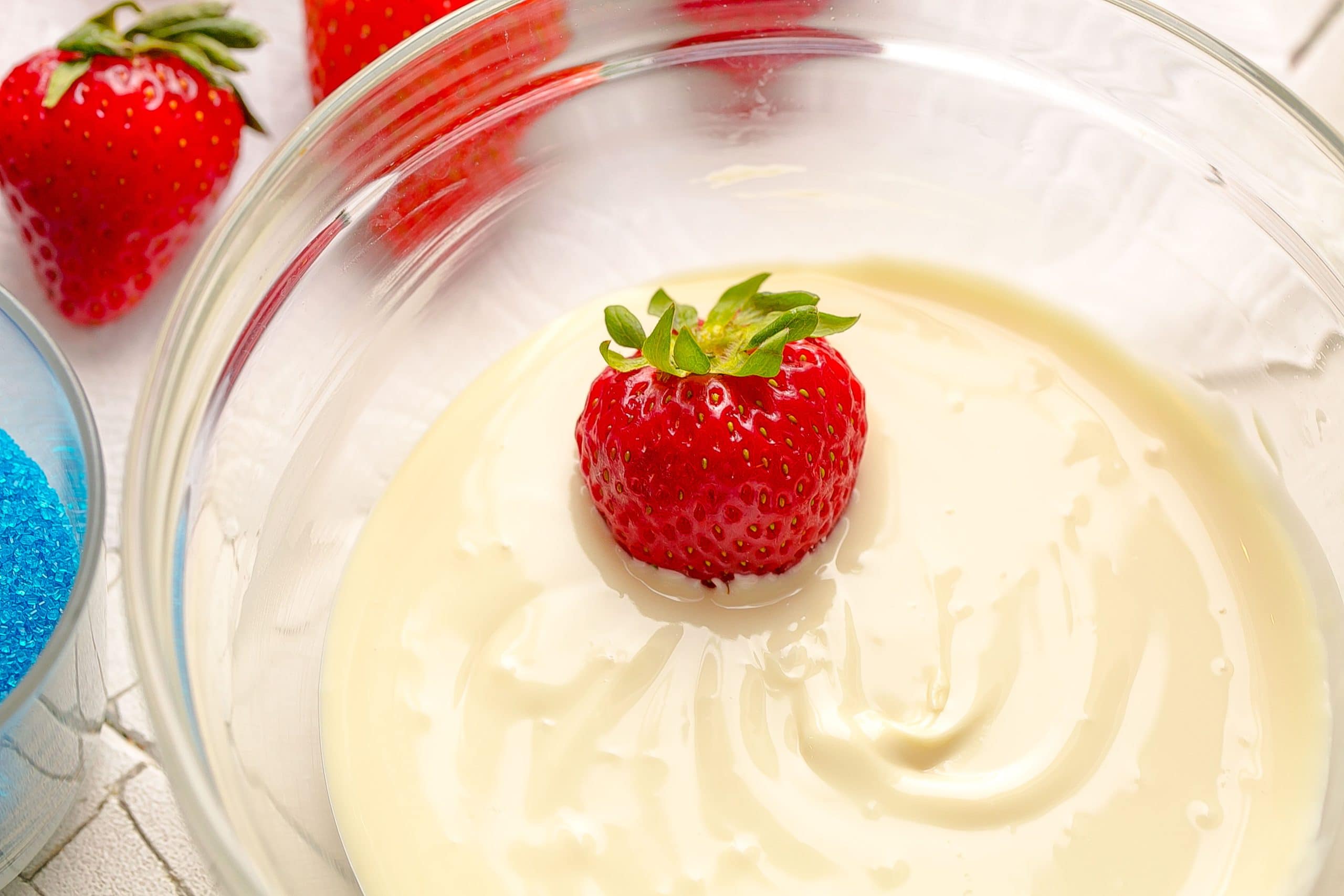 Strawberry in a bowl of melted white chocolate.