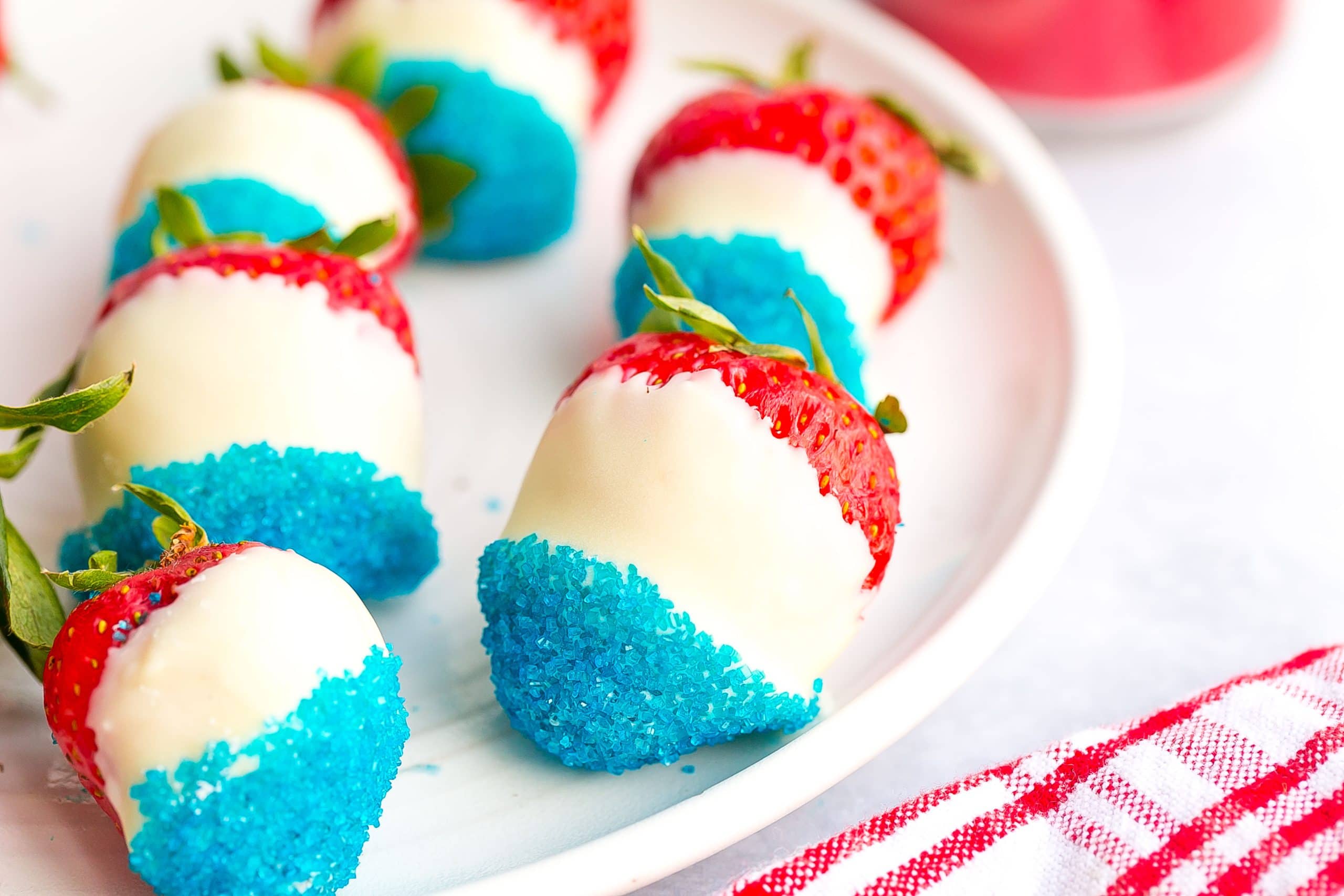 White chocolate dipped strawberries with blue sugar.
