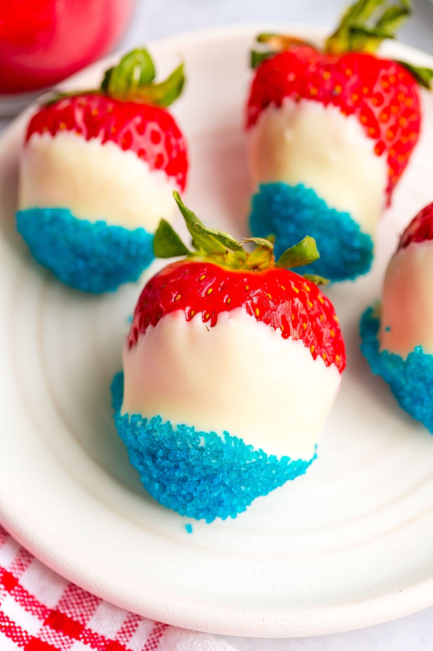 Strawberry coated in a white chocolate and blue sprinkles.