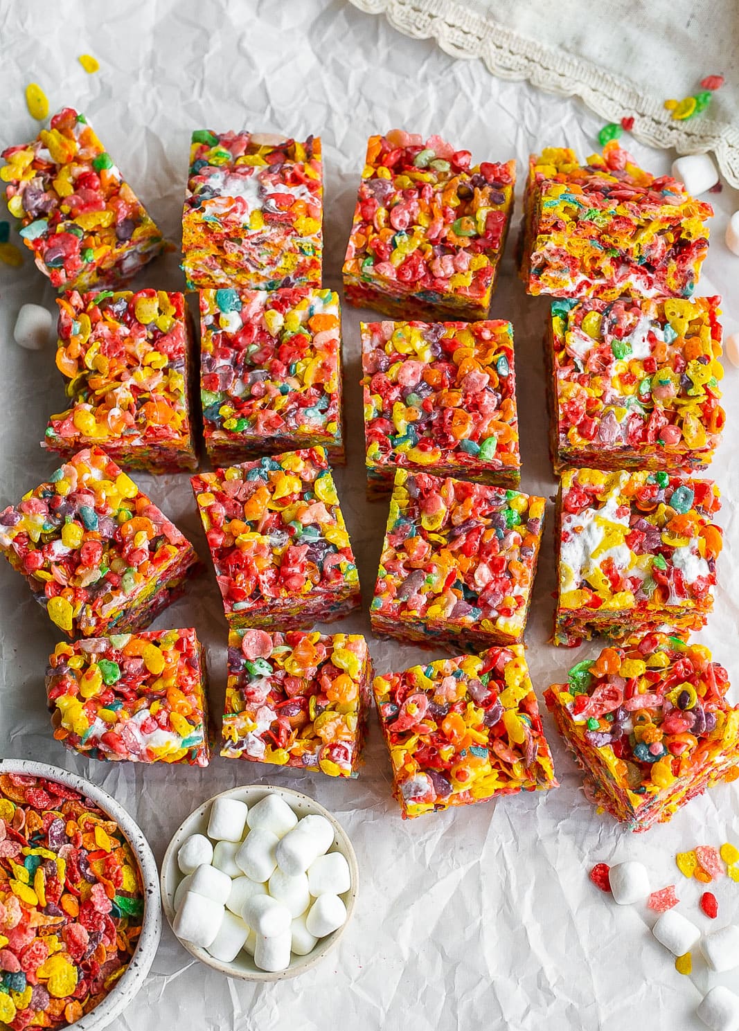 Fruity treats with marshmallows cut on parchment paper.