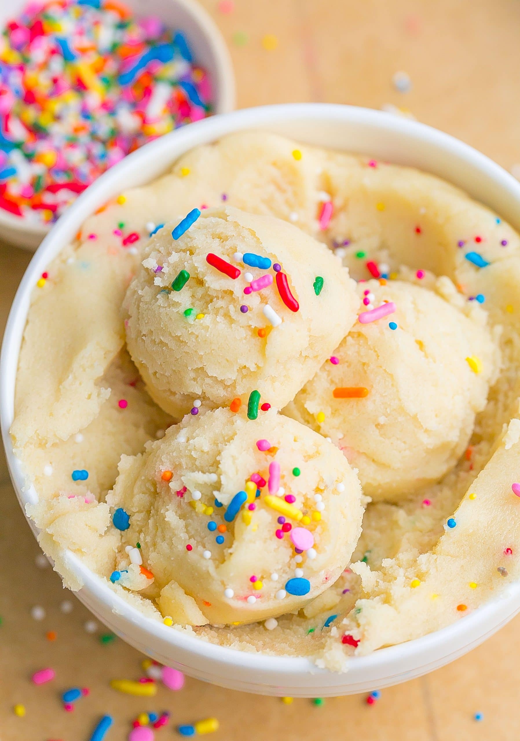 Edible sugar cookie dough with sprinkles in a bowl.