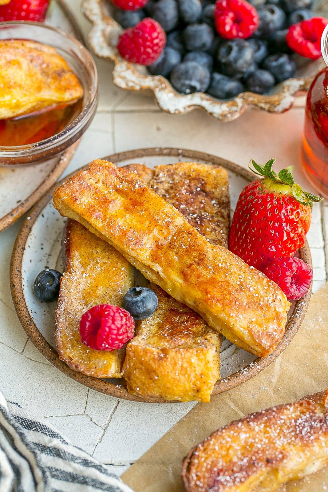 French Toast Sticks on a plate with fresh fruit.