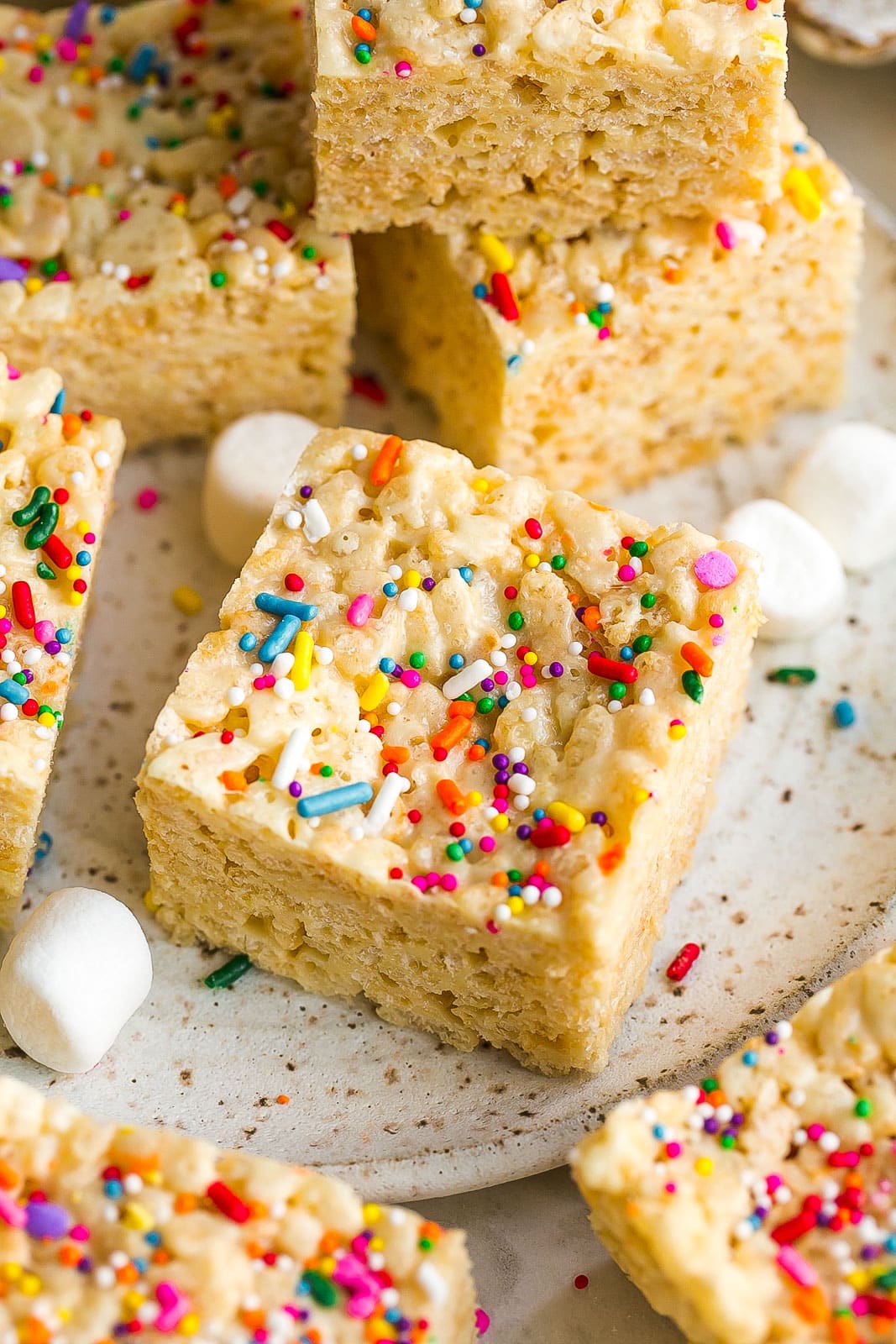 Square rice krispie treat with marshmallows and rainbow sprinkles.