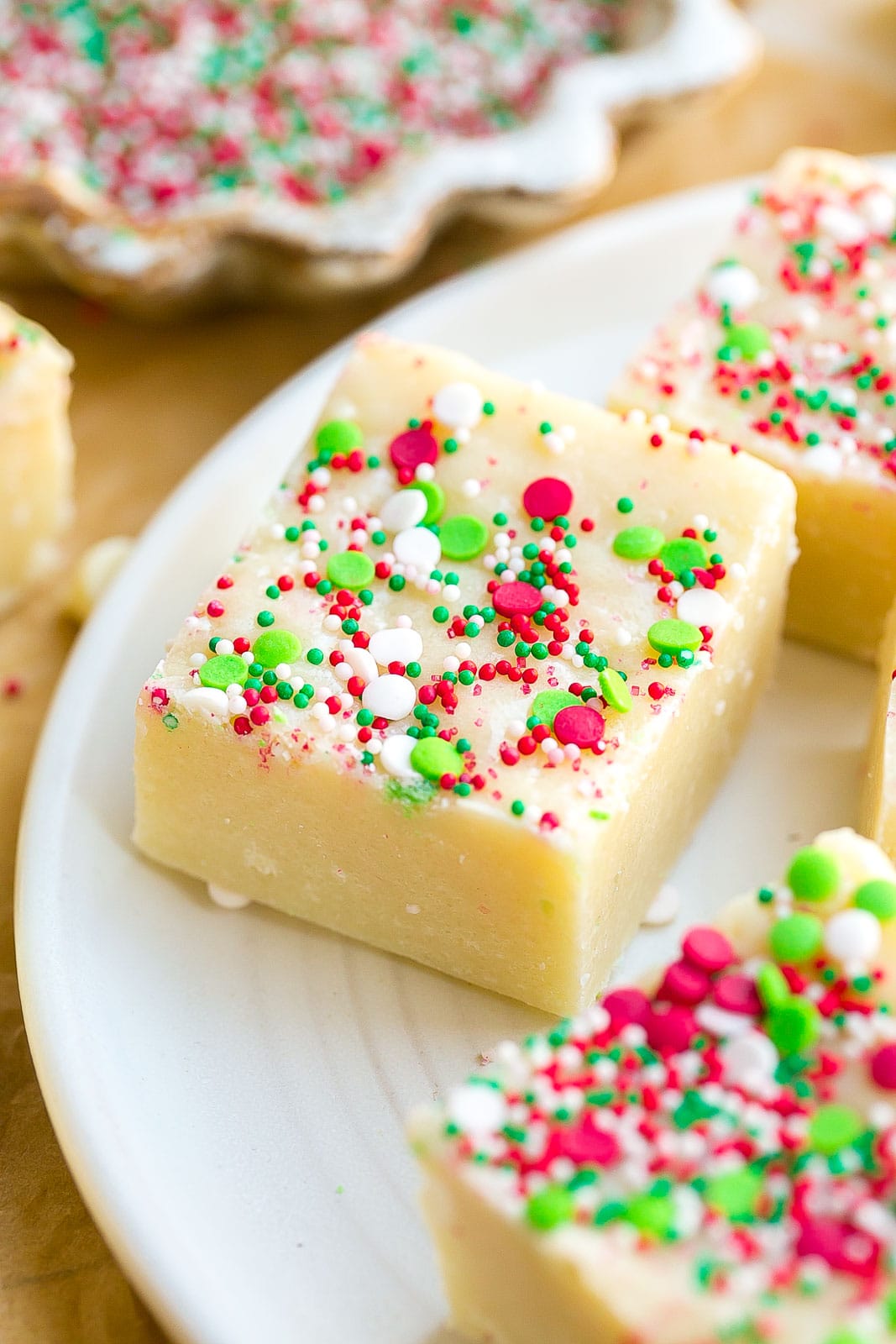 Fudge on a white plate with christmas sprinkles.
