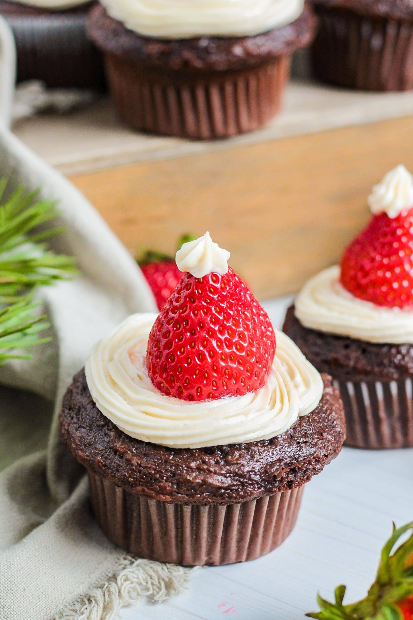 Chocolate cupcakes with strawberries on top.