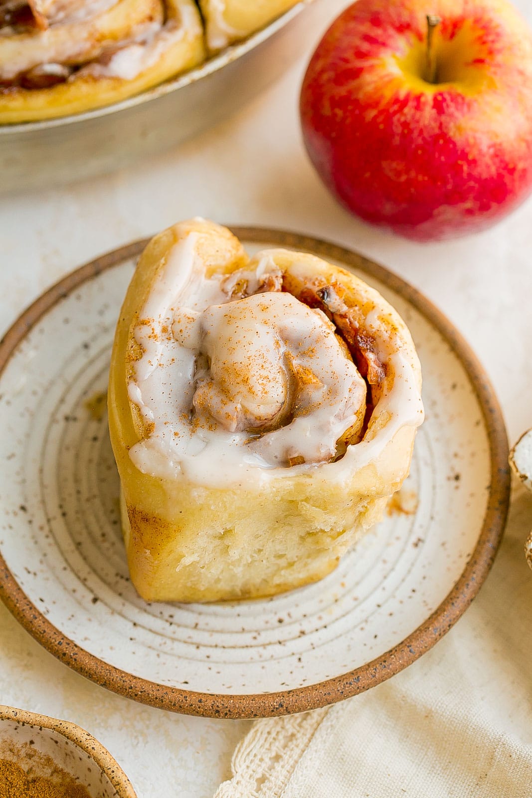 Apple pie cinnamon roll on small plate.