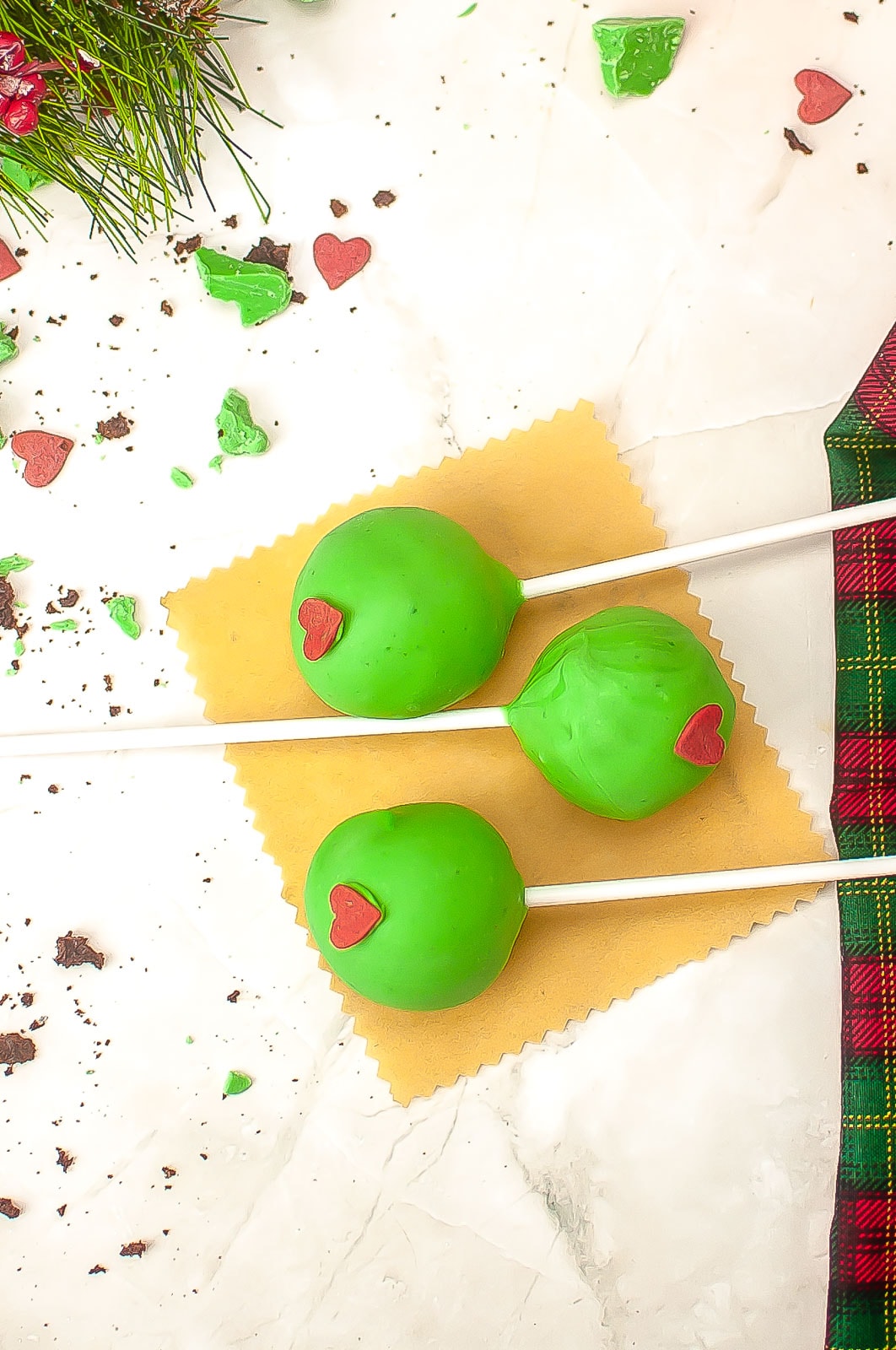 Green cake pops with heart sprinkle.