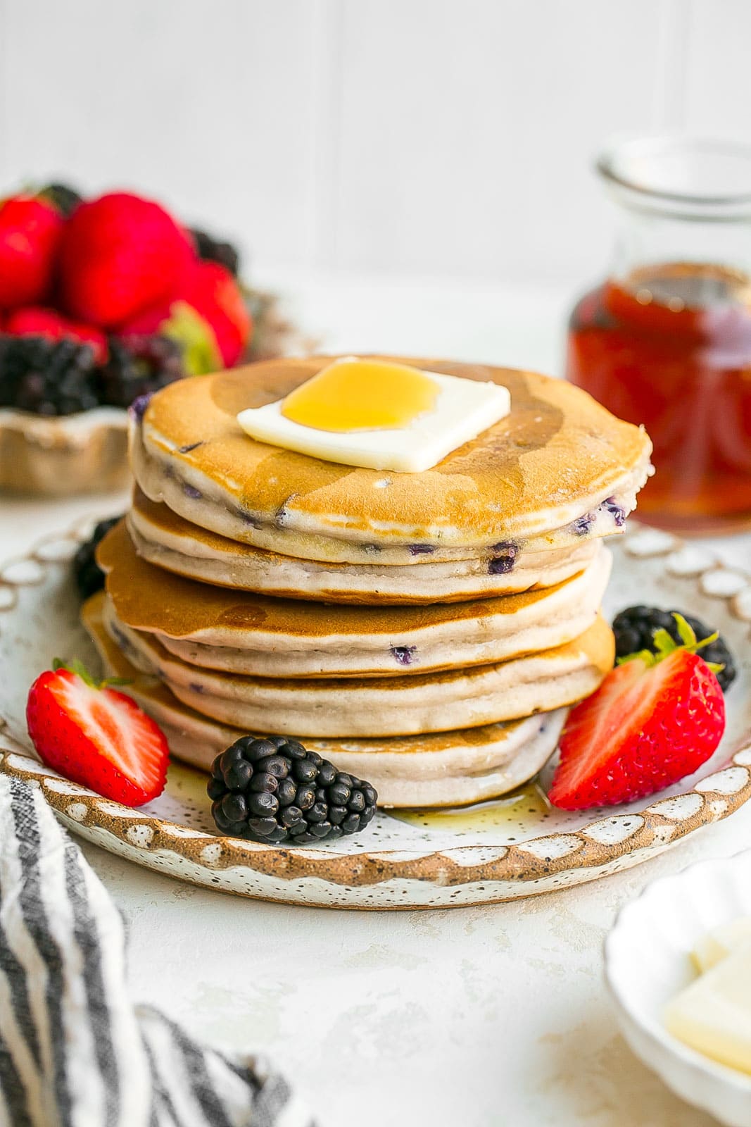 Tall stack of pancakes with fresh berries.