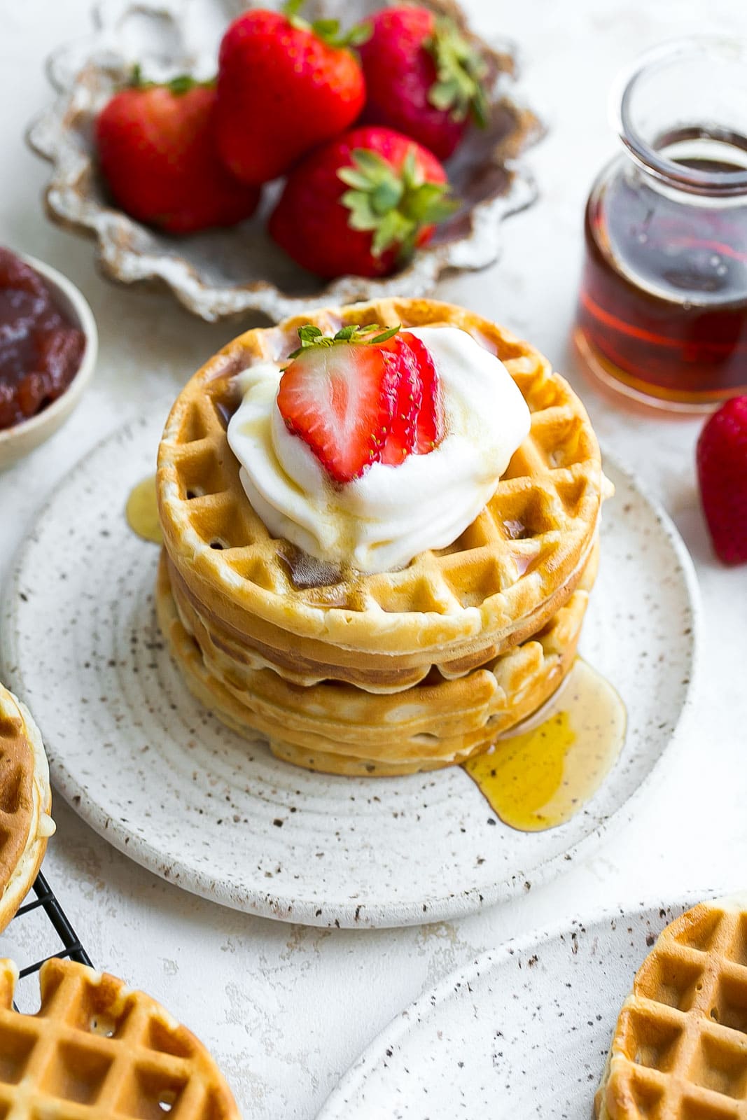 Waffles on a plate with maple syrup.