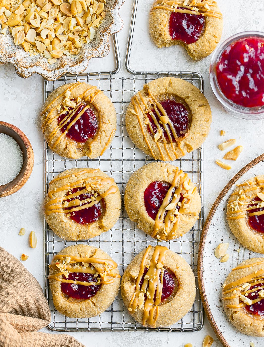 Peanut butter cookies on a cooling rack with jelly.