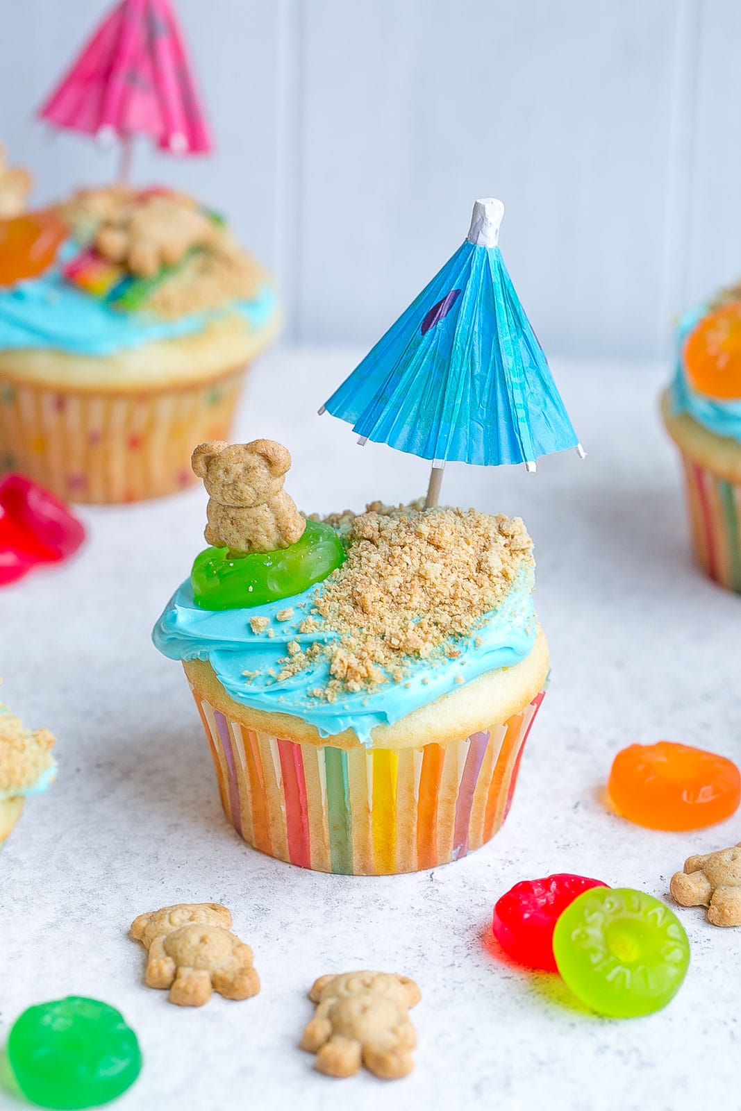 Beach cupcakes with paper umbrellas and teddy grahams.