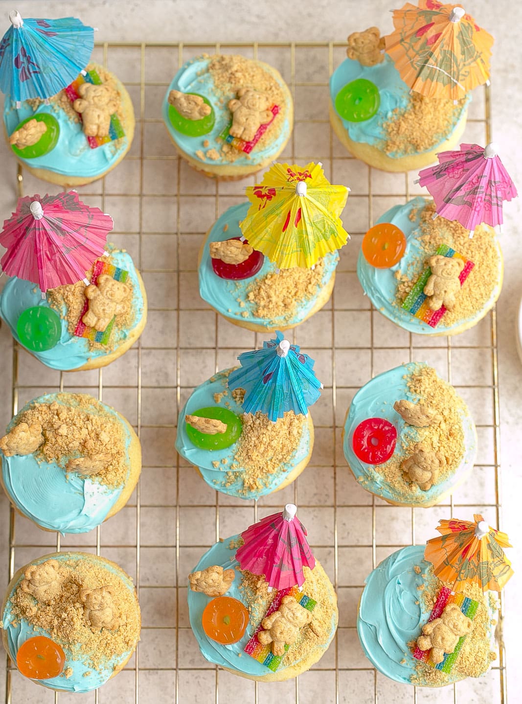 Beach cupcakes on a wire rack.