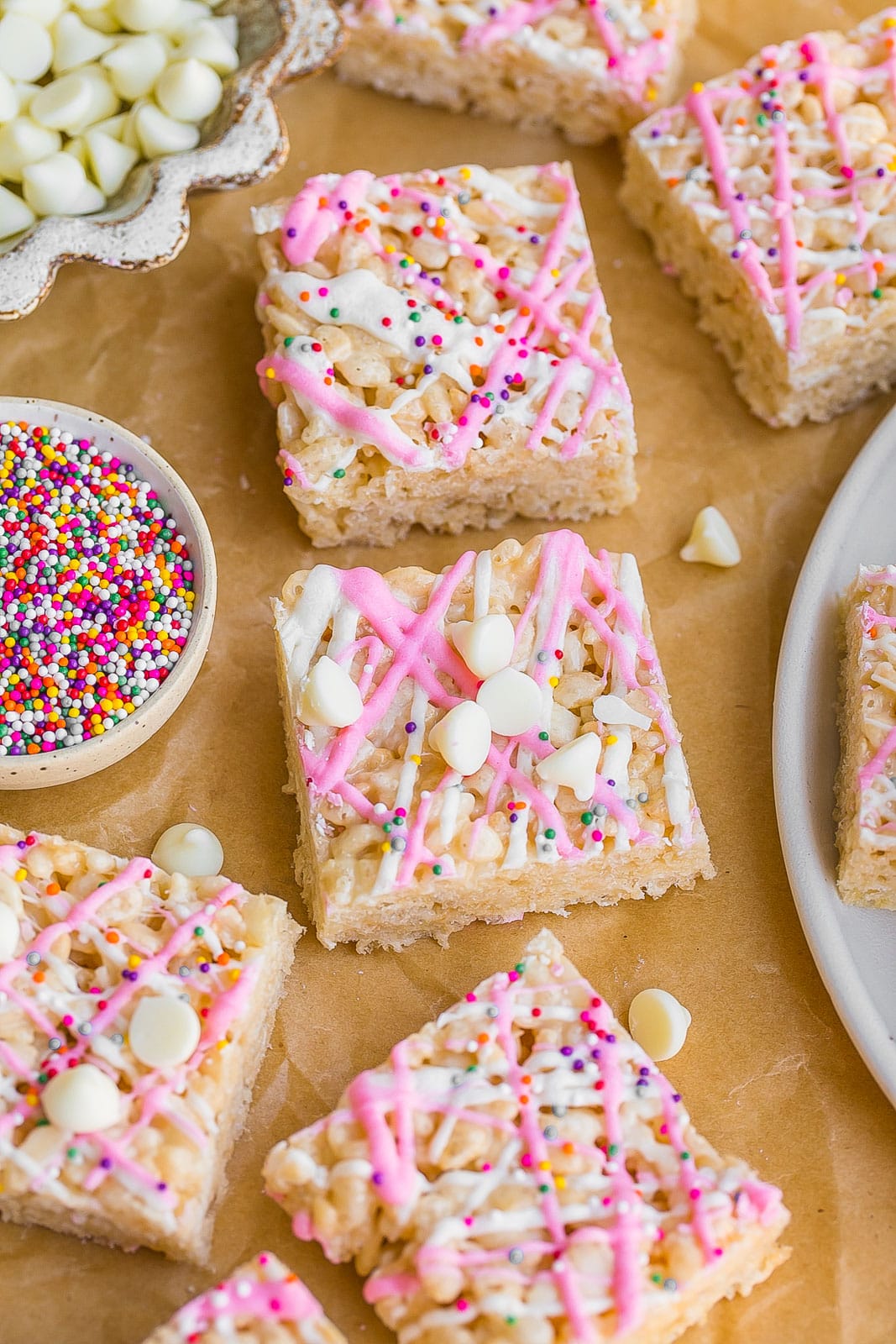 Rice krispie treats with white chocolate on top and sprinkles.