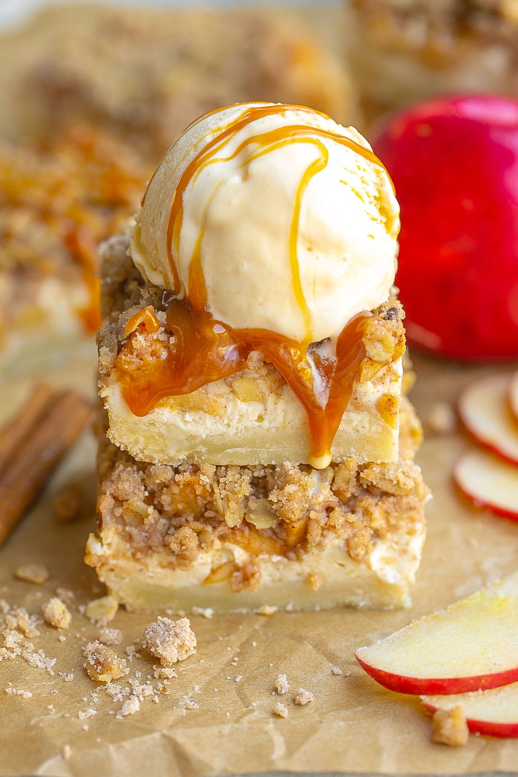 Stack of apple pie cheesecake bars with ice cream on top.