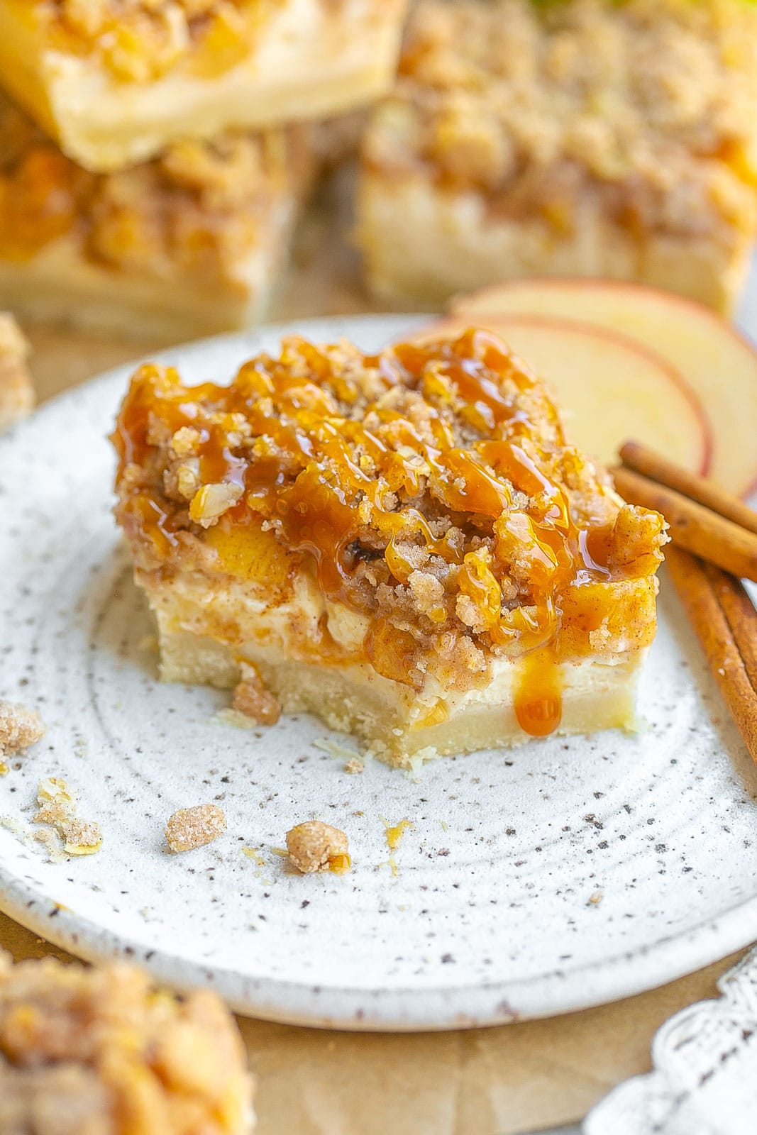 Caramel Apple Cheesecake Bar on plate with bite taken out.