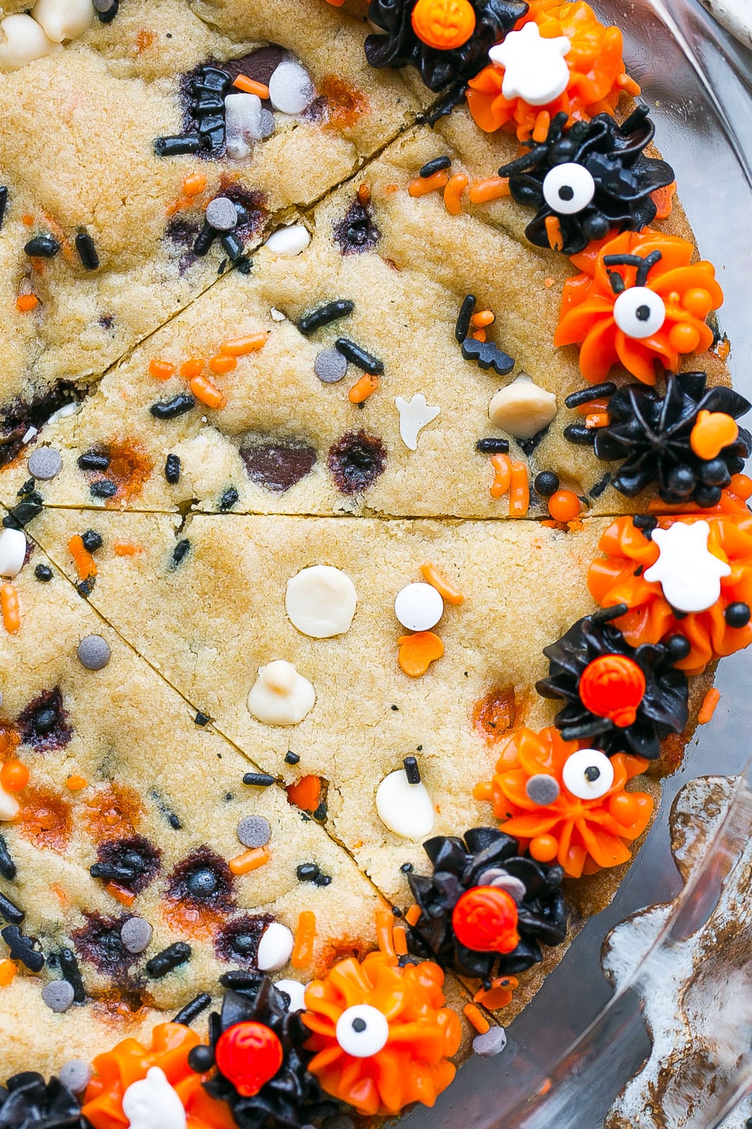 Halloween cookie topped with frosting and sprinkles.