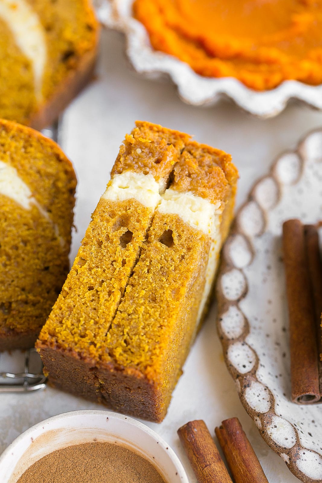 Piece of pumpkin bread sliced in half.