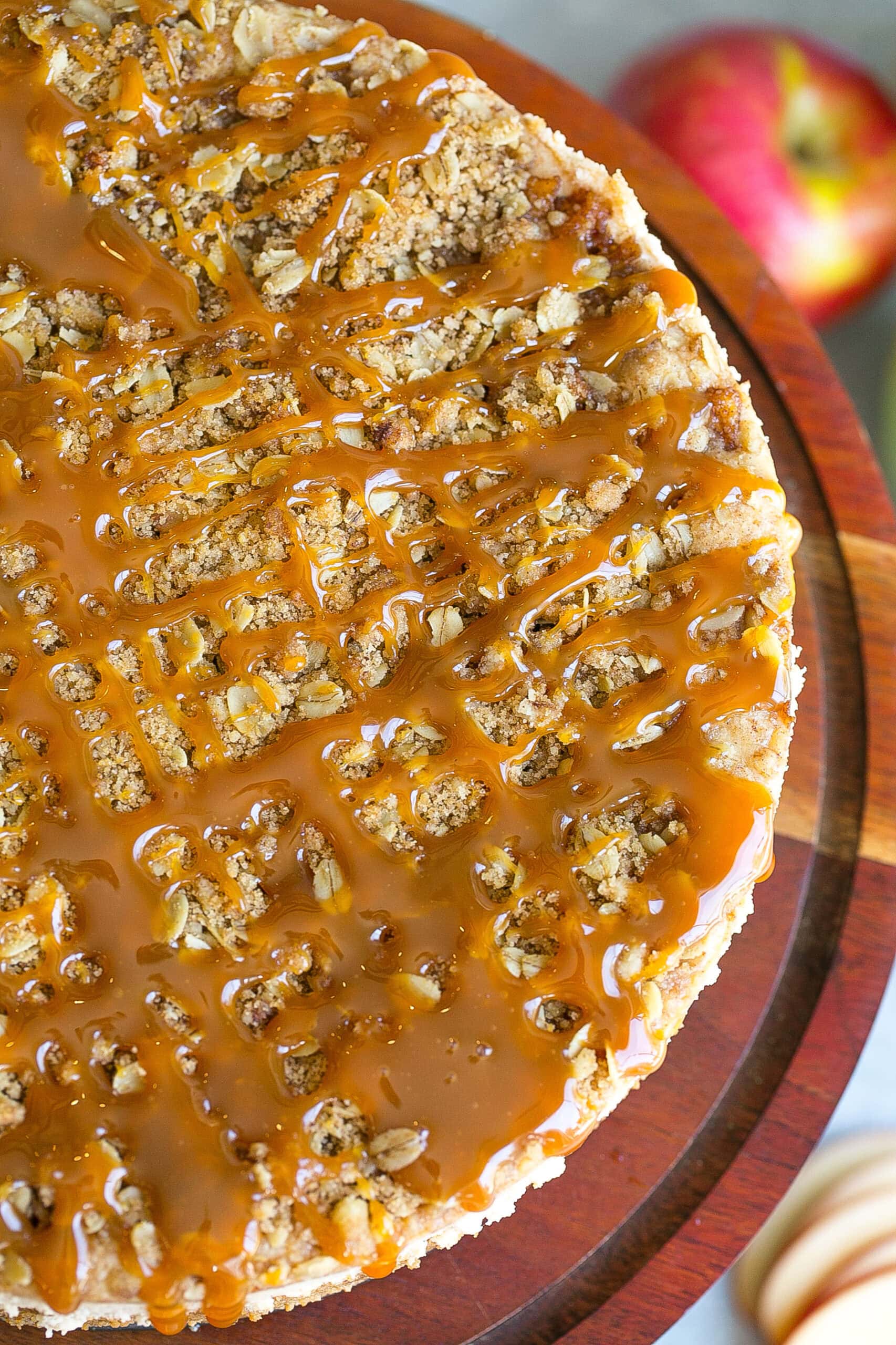 Lots of caramel sauce on top of an apple pie cheesecake.