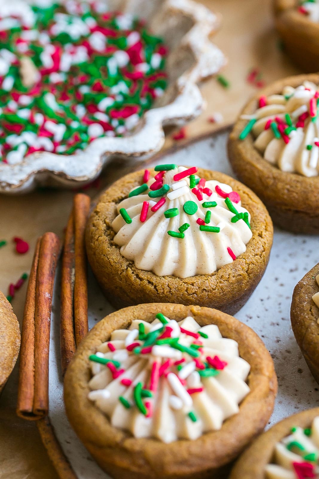 Gingerbread cookie cups on a plate with cinnamon sticks.