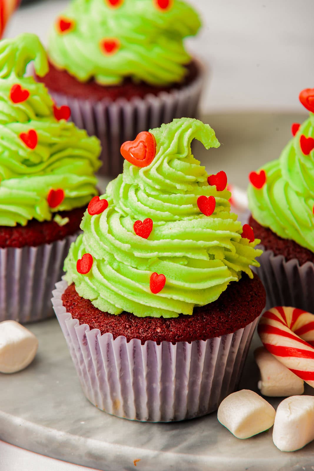 Grinch cupcake with mini marshmallows and a candy cane.