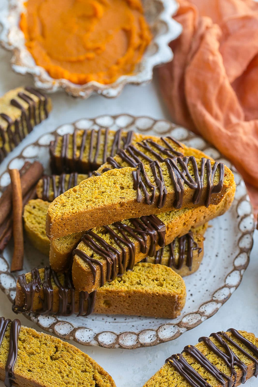 Pumpkin Biscotti cookies drizzled with chocolate on a plate.