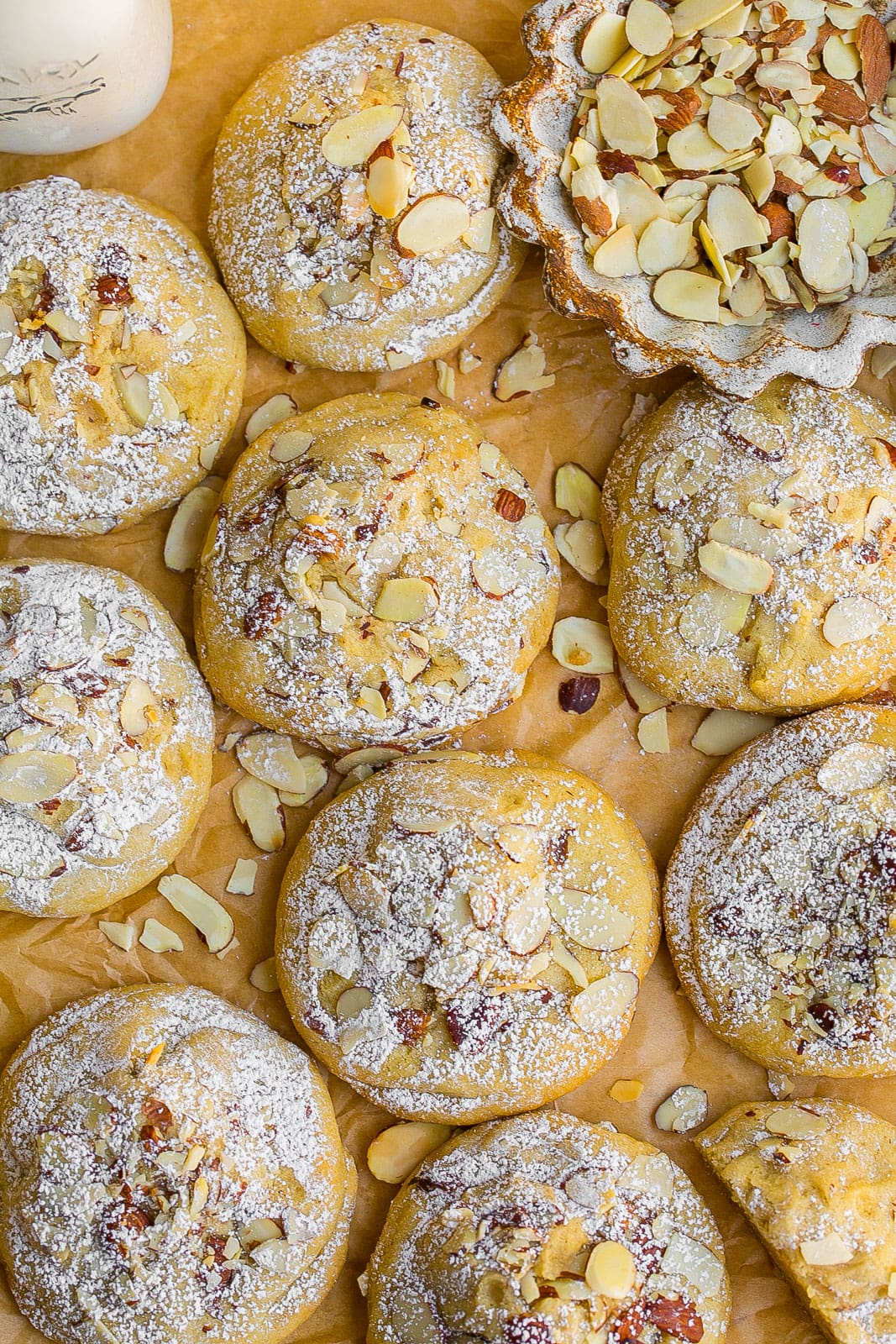 Almond Croissant Cookies on parchment paper with sliced almonds.