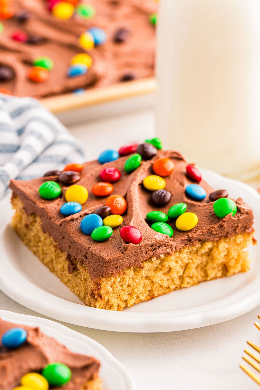 A piece of Peanut Butter Sheet Cake with a creamy chocolate peanut butter frosting on top.