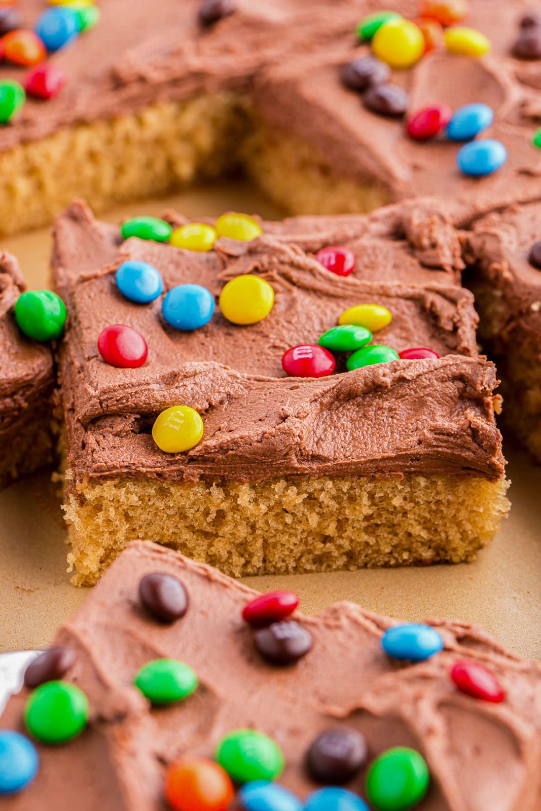 This Peanut Butter Sheet Cake is a moist, soft, and tender cake packed with peanut butter flavor. Topped with a creamy and smooth chocolate peanut butter frosting and colorful mini M&M's. It's quick to make and perfect for all occasions!