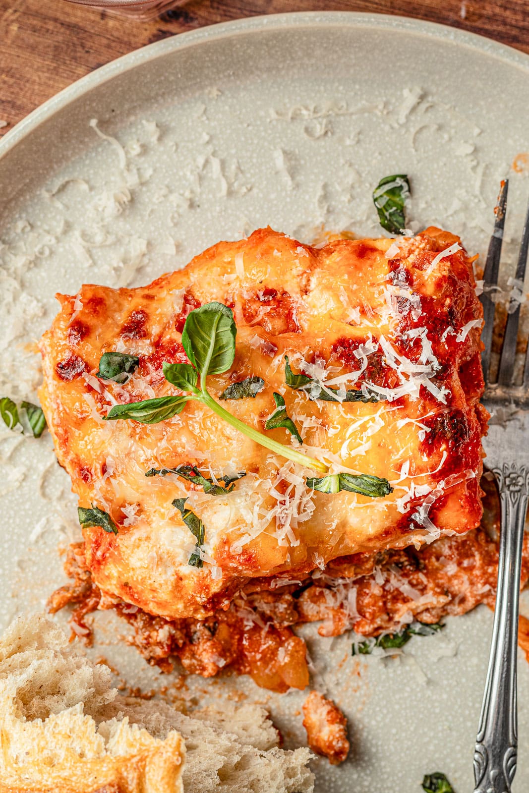 A serving of Lazy Lasagna recipe on a dish with grated parmesan cheese. 