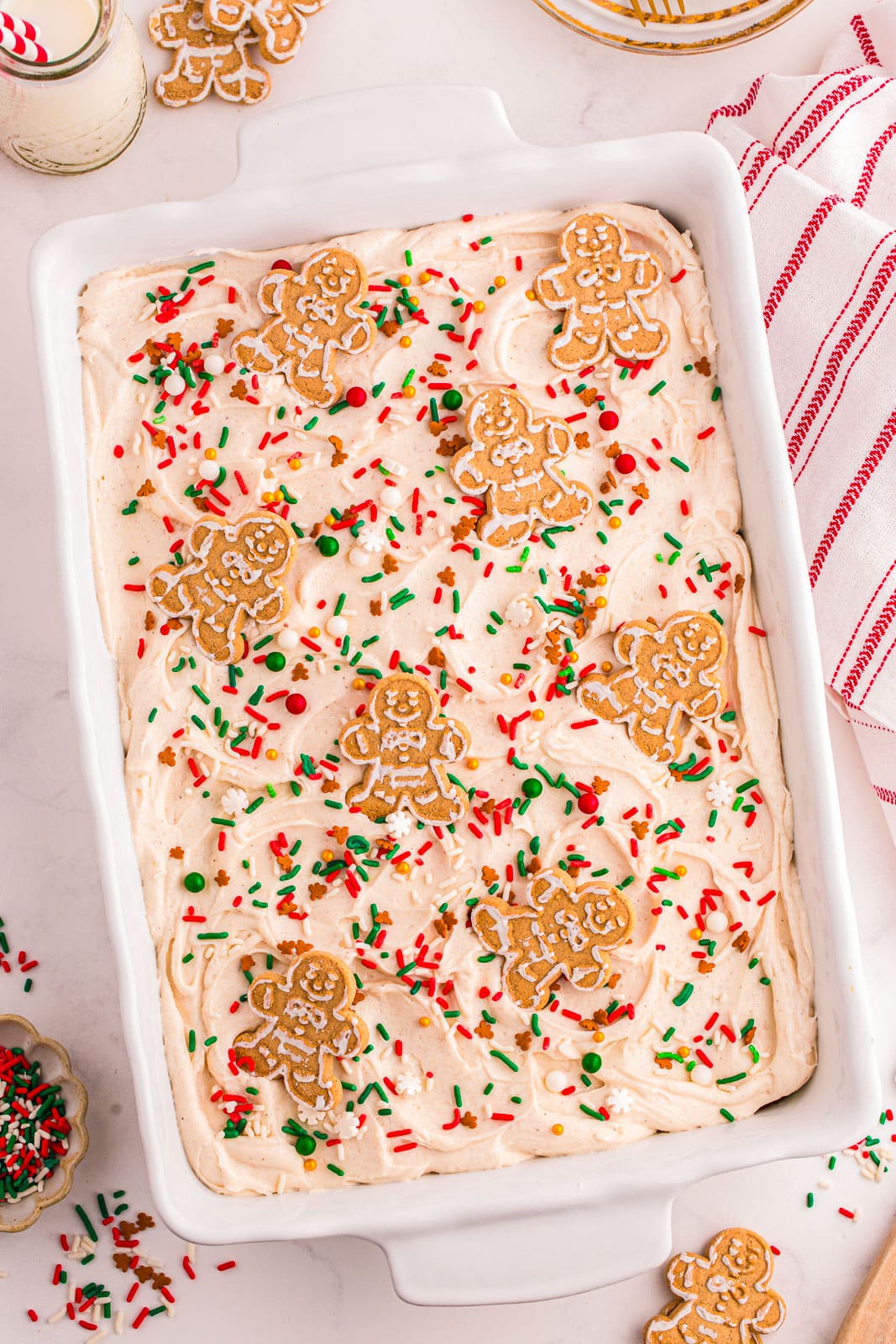 Gingerbread Sheet Cake topped with a creamy cream cheese frosting, festive sprinkles, and cute little gingerbread cookies. 