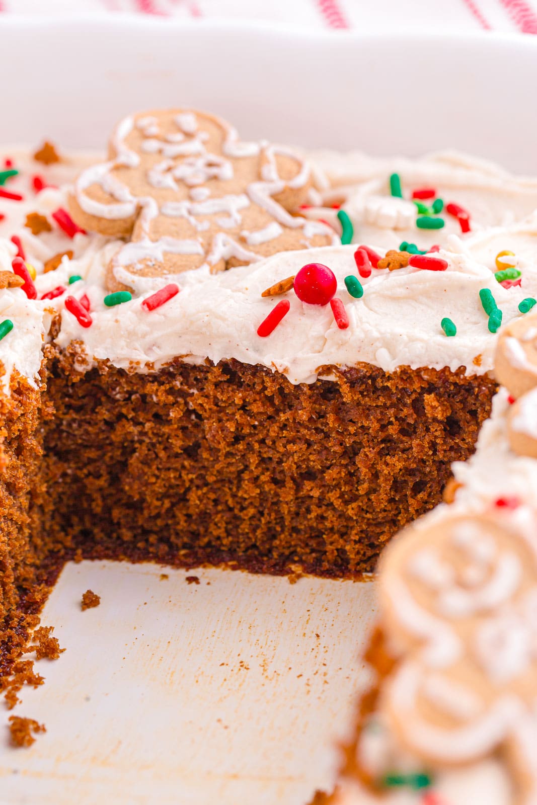 Gingerbread Sheet Cake topped with a creamy cream cheese frosting, festive sprinkles, and cute little gingerbread cookies. 