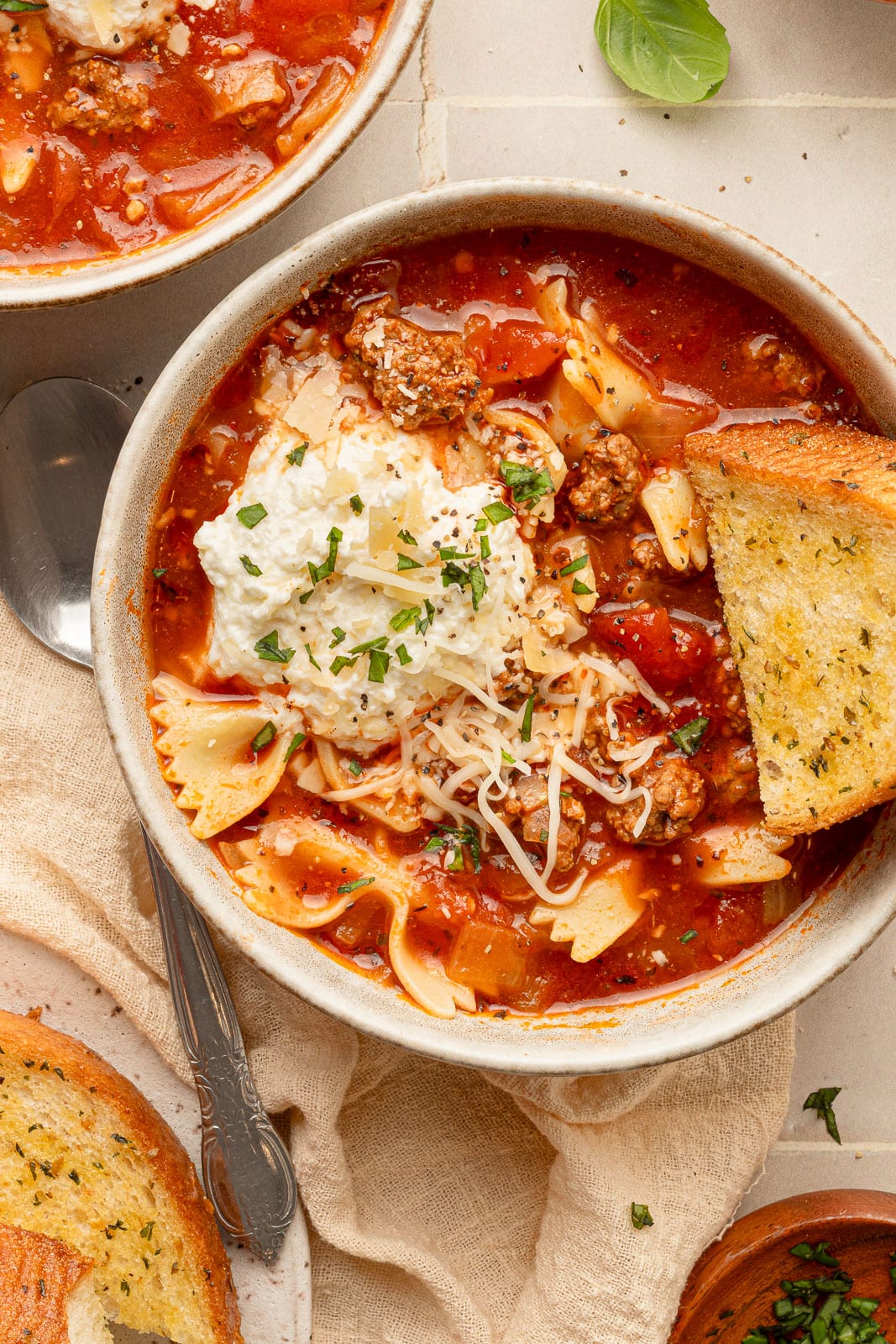 One-pot Lasagna Soup in a bowl with garlic bread. 