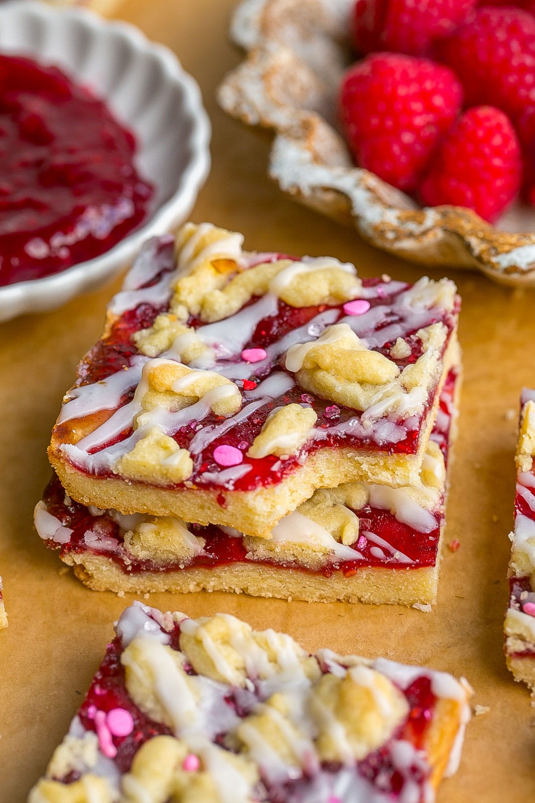 Short stack of raspberry cookie bars with bite mark.