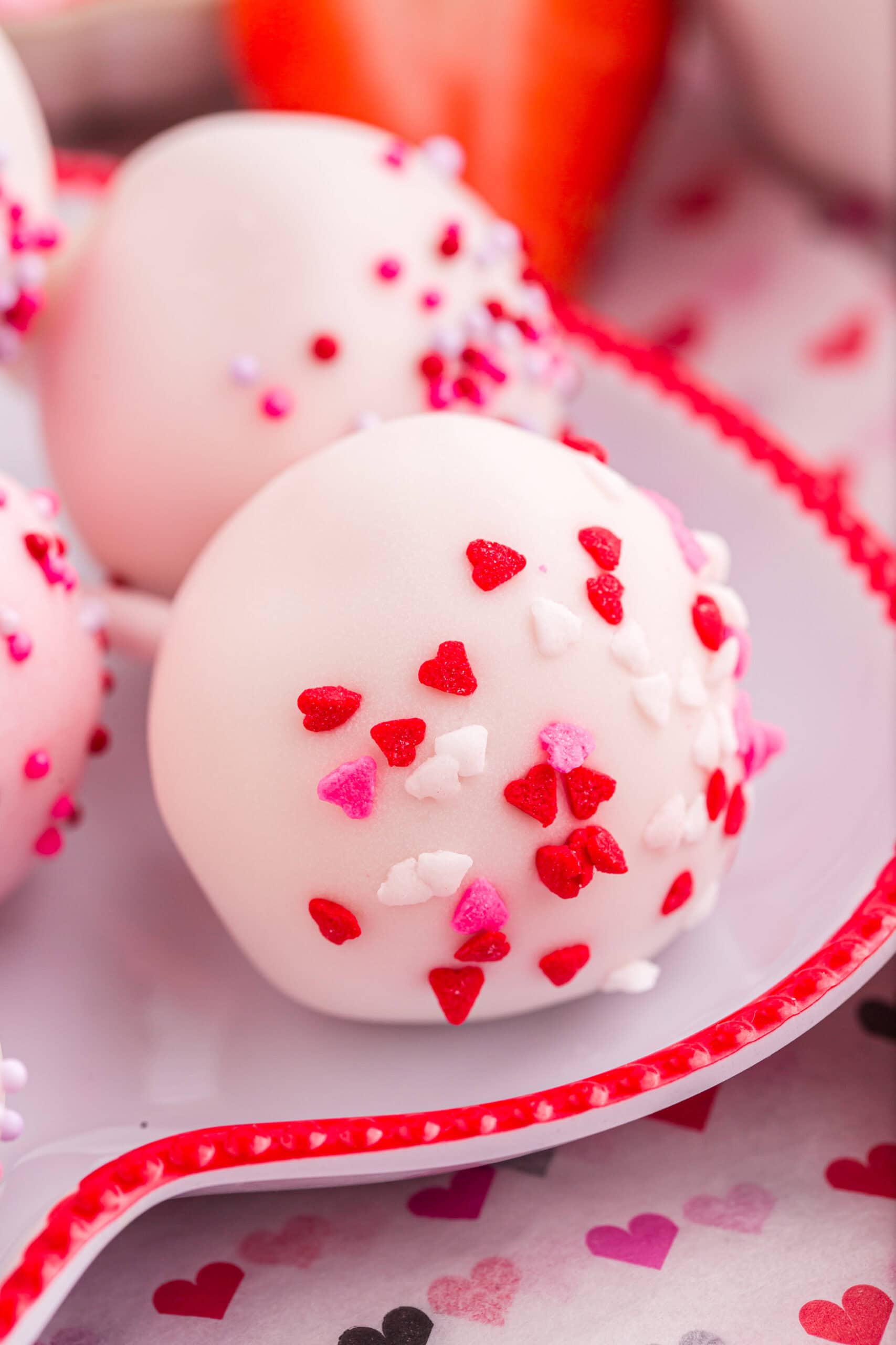 Strawberry Cake Pop with heart sprinkles.