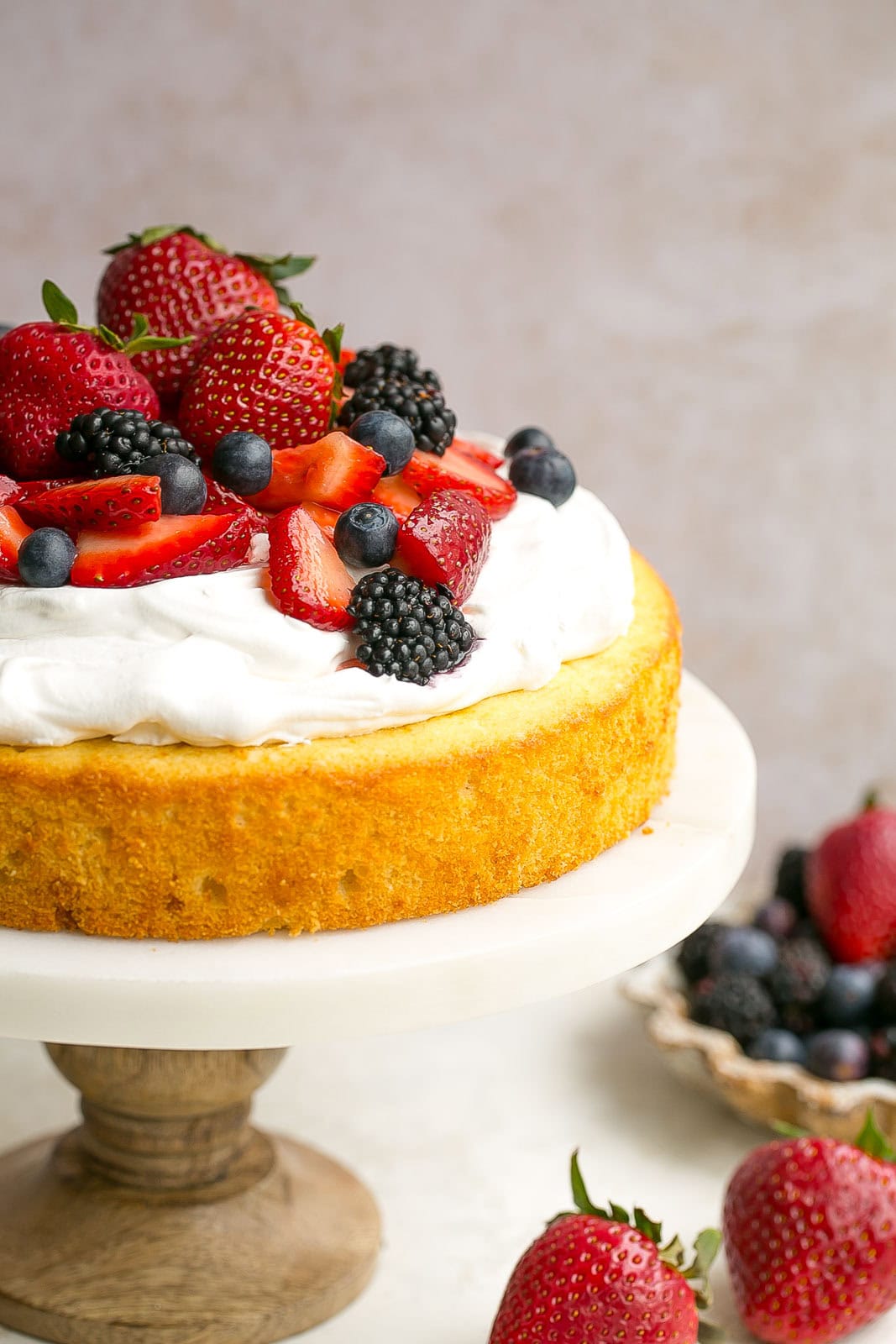 Homemade vanilla cake with whipped cream and berries on top. 
