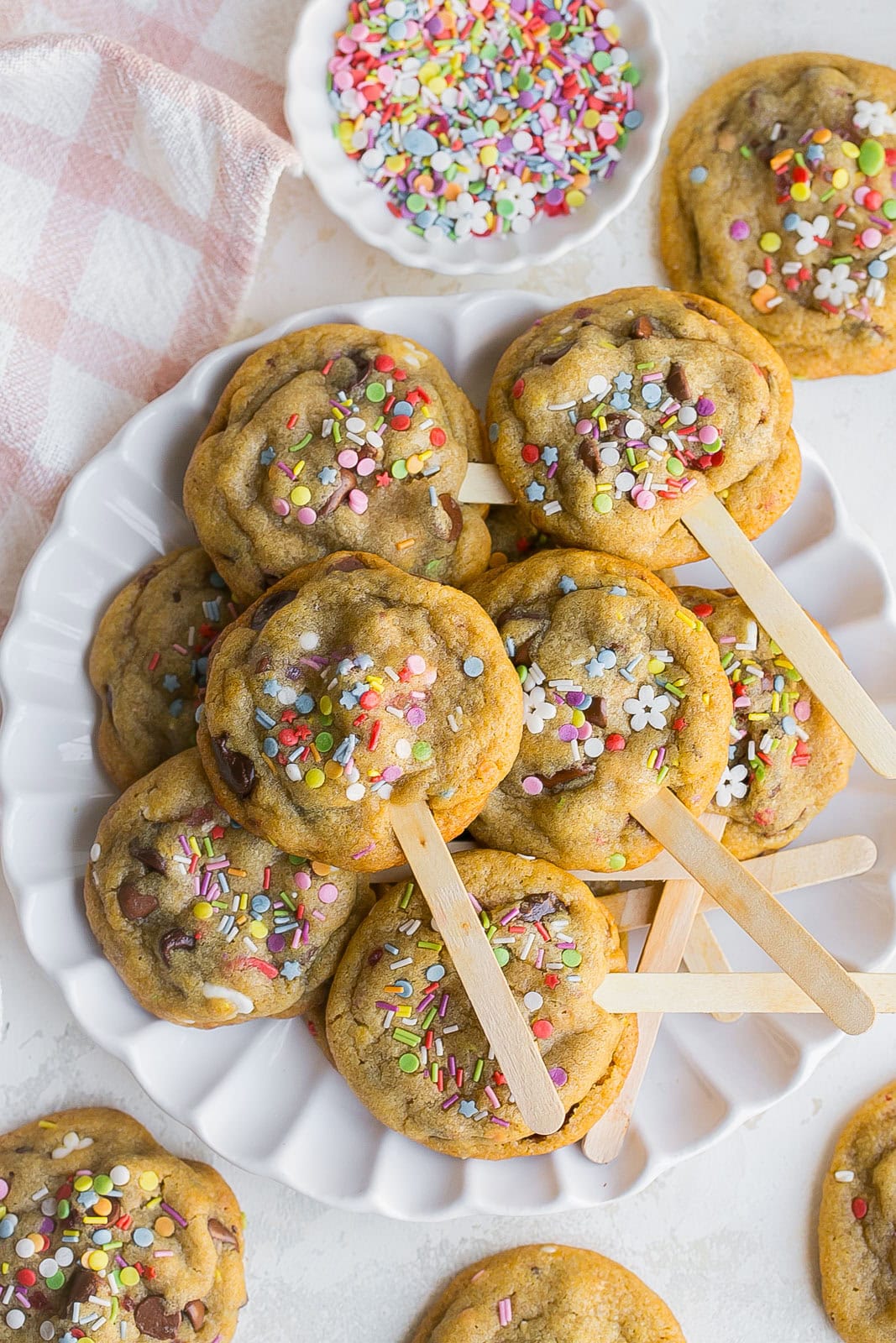 Cookie pops on a stick with sprinkles.