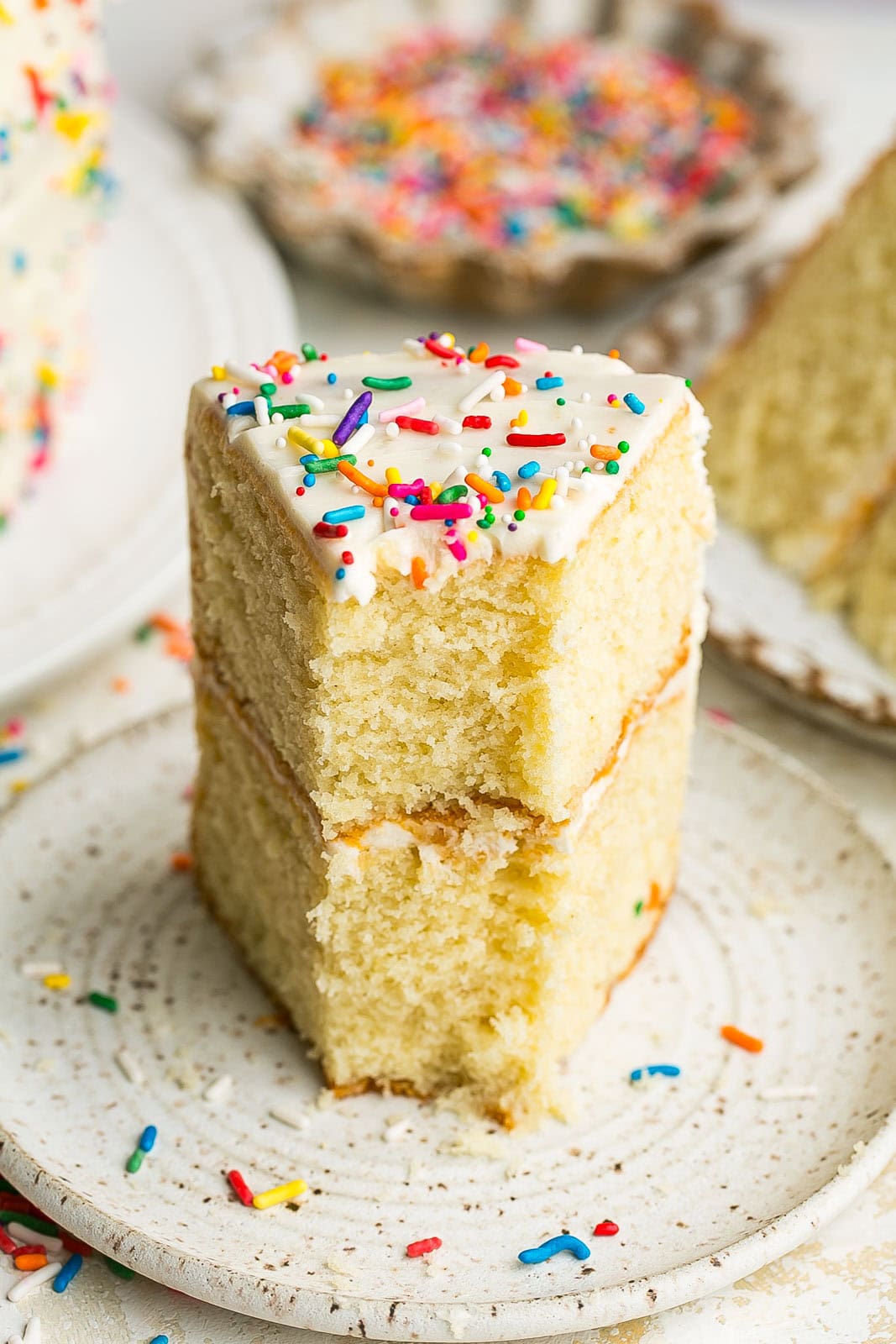 Front view of a vanilla cake with bite.