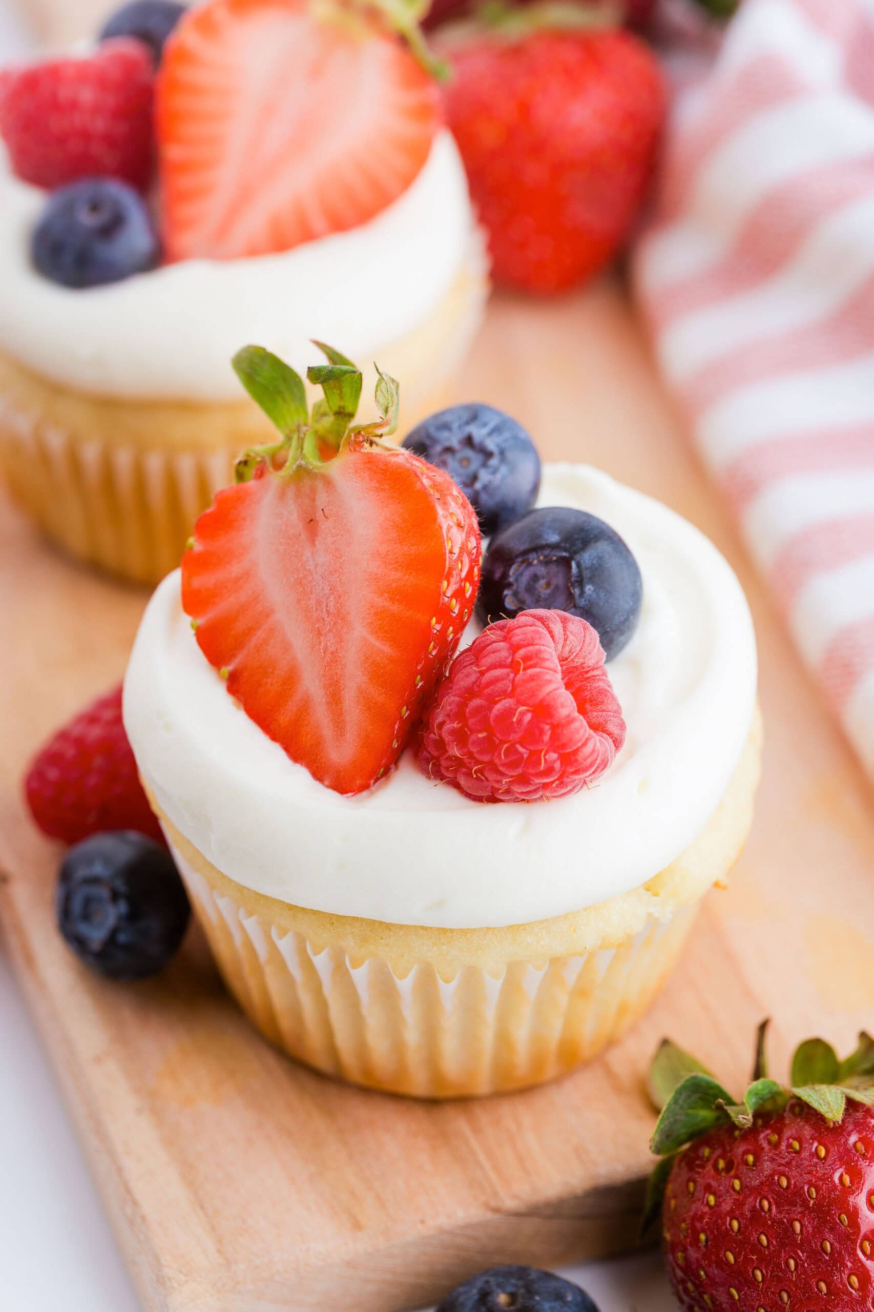 Vanilla cupcake with fresh berries on top.