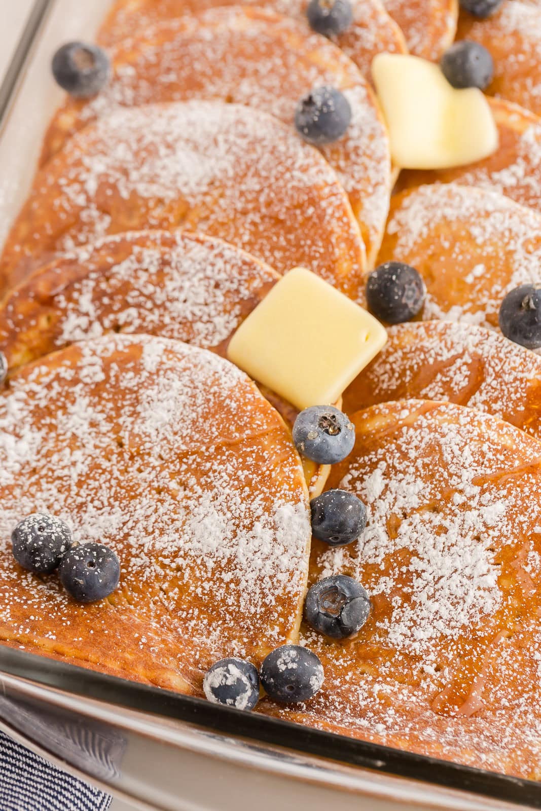 Pancake casserole with butter and blueberries on top.