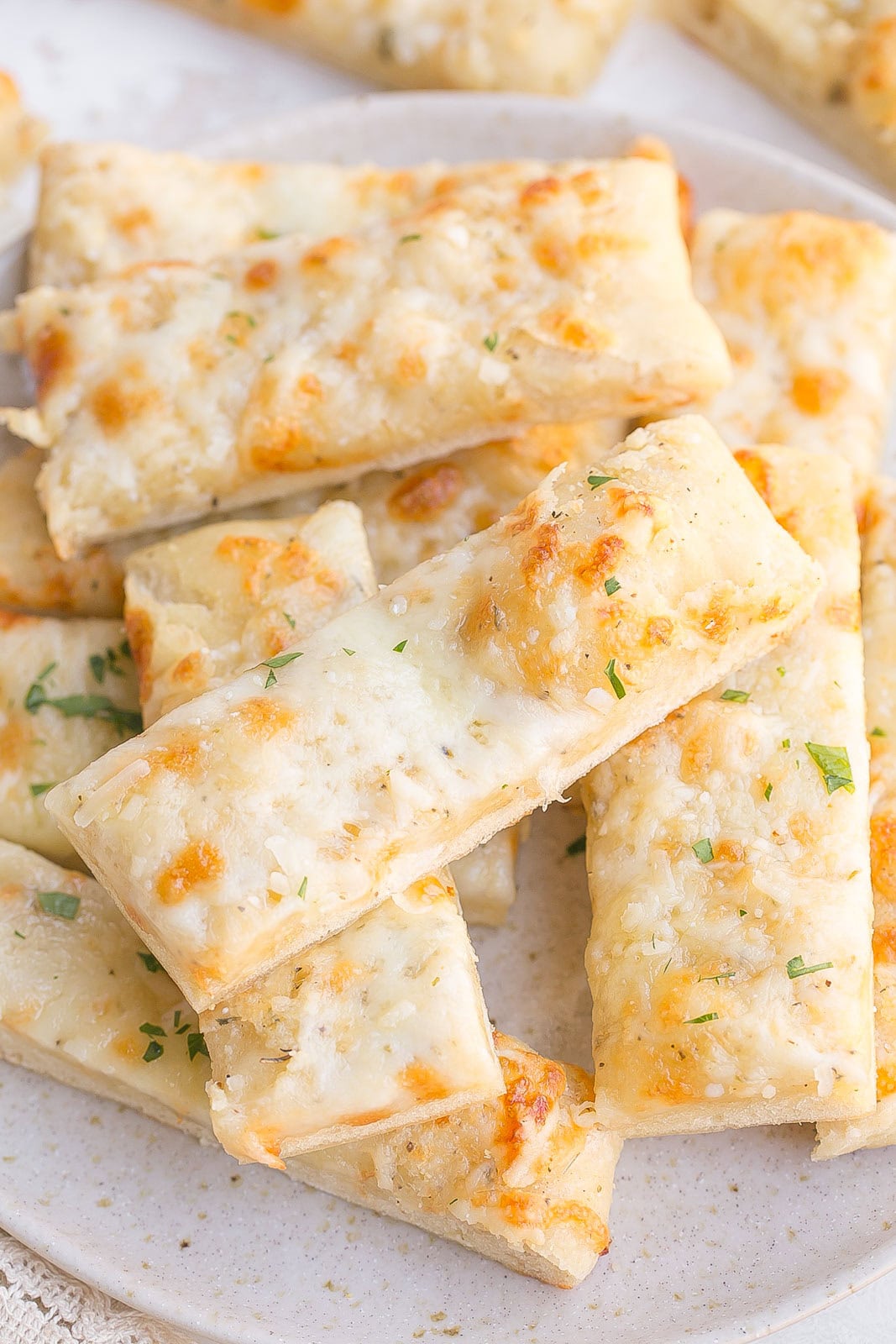 Plate full of breadsticks.