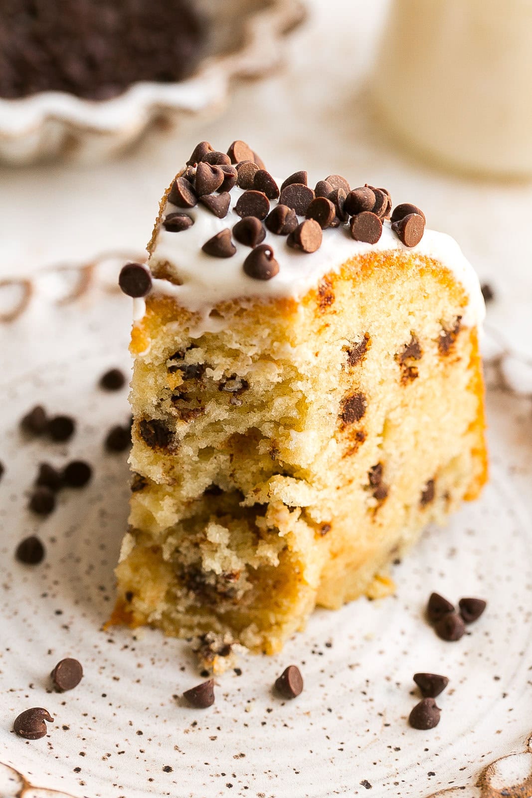 Piece of frosted bundt cake with chocolate chips.