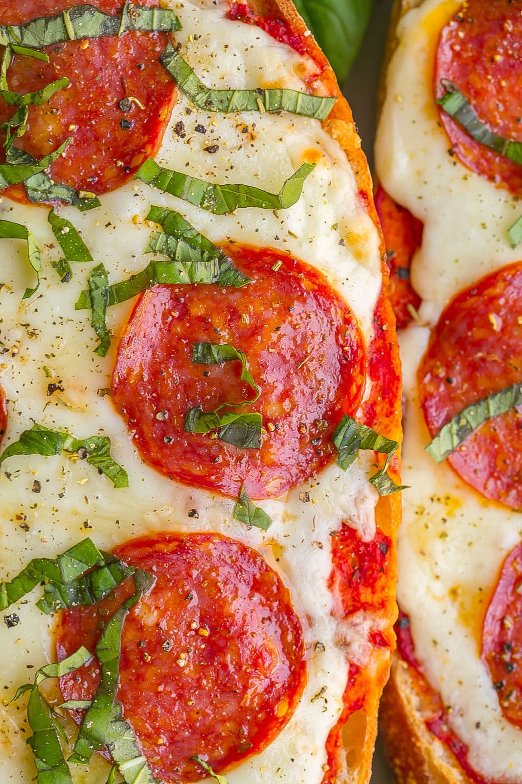 Close up of pepperoni on pizza bread.