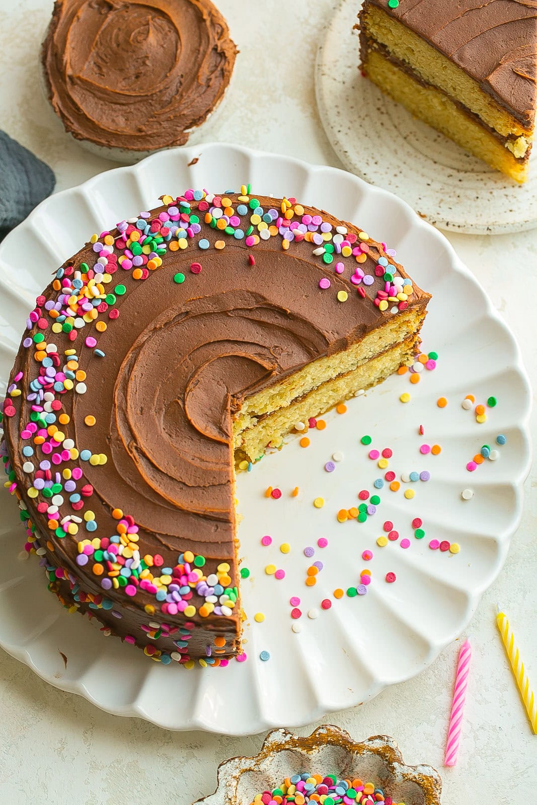 Yellow Birthday Cake with chocolate frosting and sprinkles.