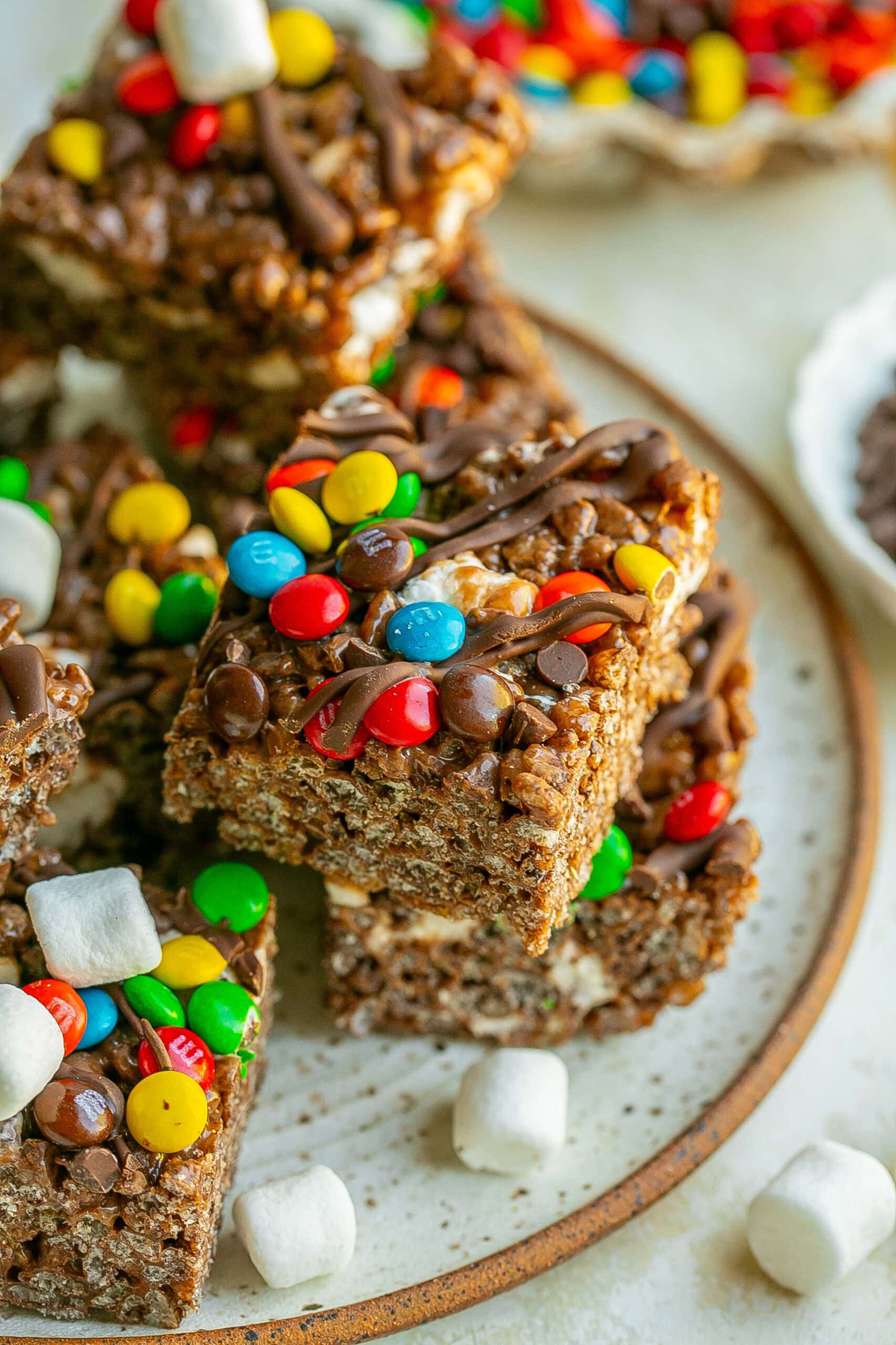 Plate full of No Bake Rice Krispie Treats with chocolate and M&Ms.